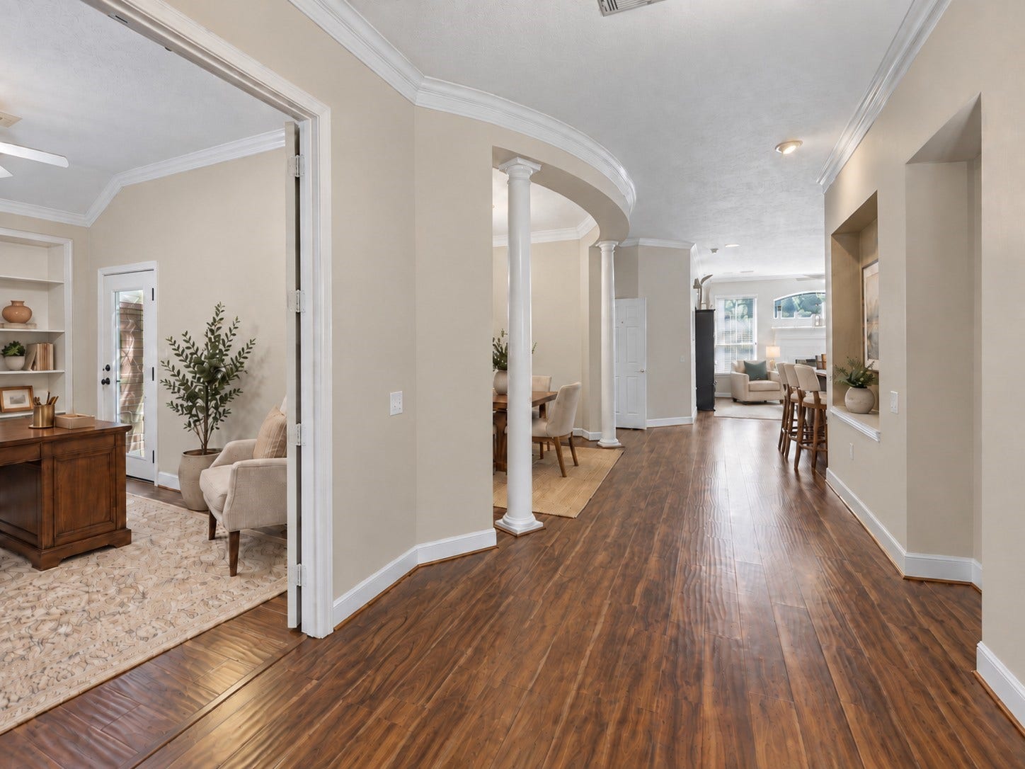 The interior opens with graceful columns, curved architectural details, and a clear sightline toward the main living areas.**Virtually staged
