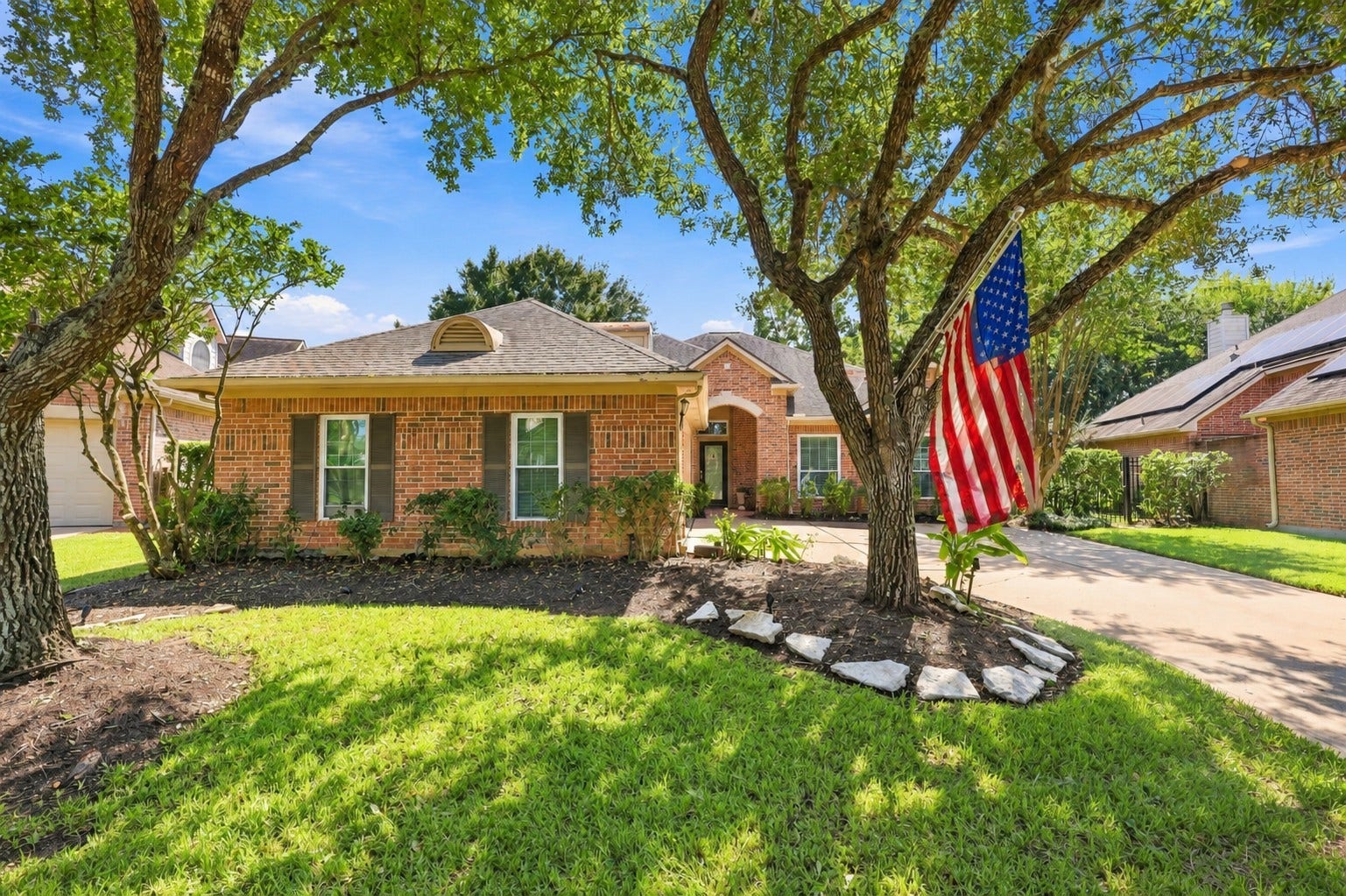 Welcome to 8742 Rippling Water Drive, a beautifully established home in the master-planned community of Greatwood, framed by mature trees and classic brick architecture.