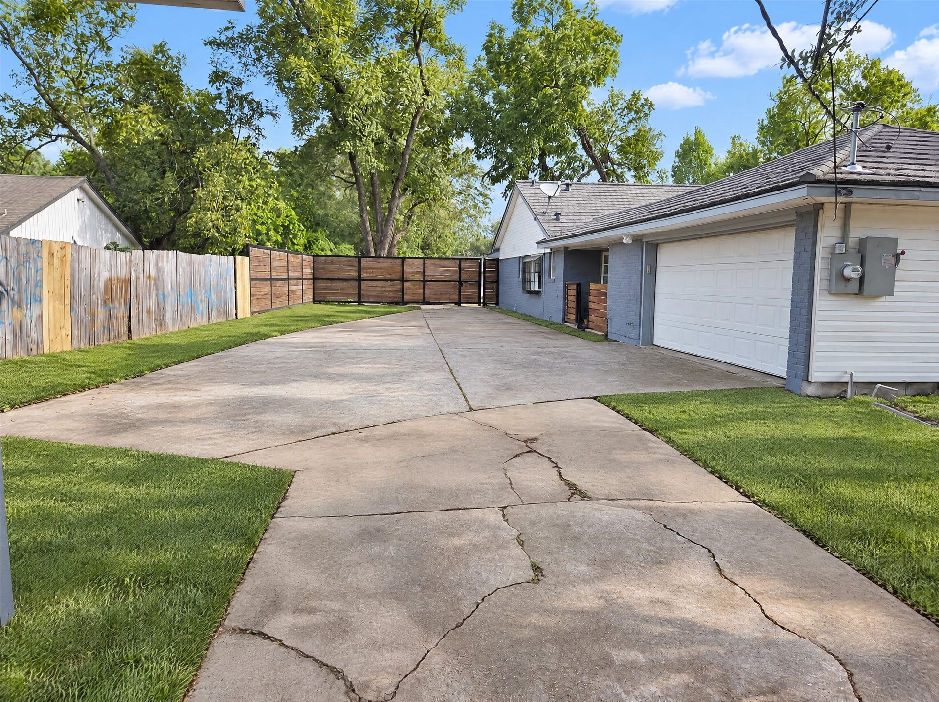 16411 Amcreek Road, Houston, TX 77068 An oversized concrete driveway provides abundant off-street parking, room for recreational vehicles or guests, and leads to an attached garage alongside a secure, gated rear perimeter.