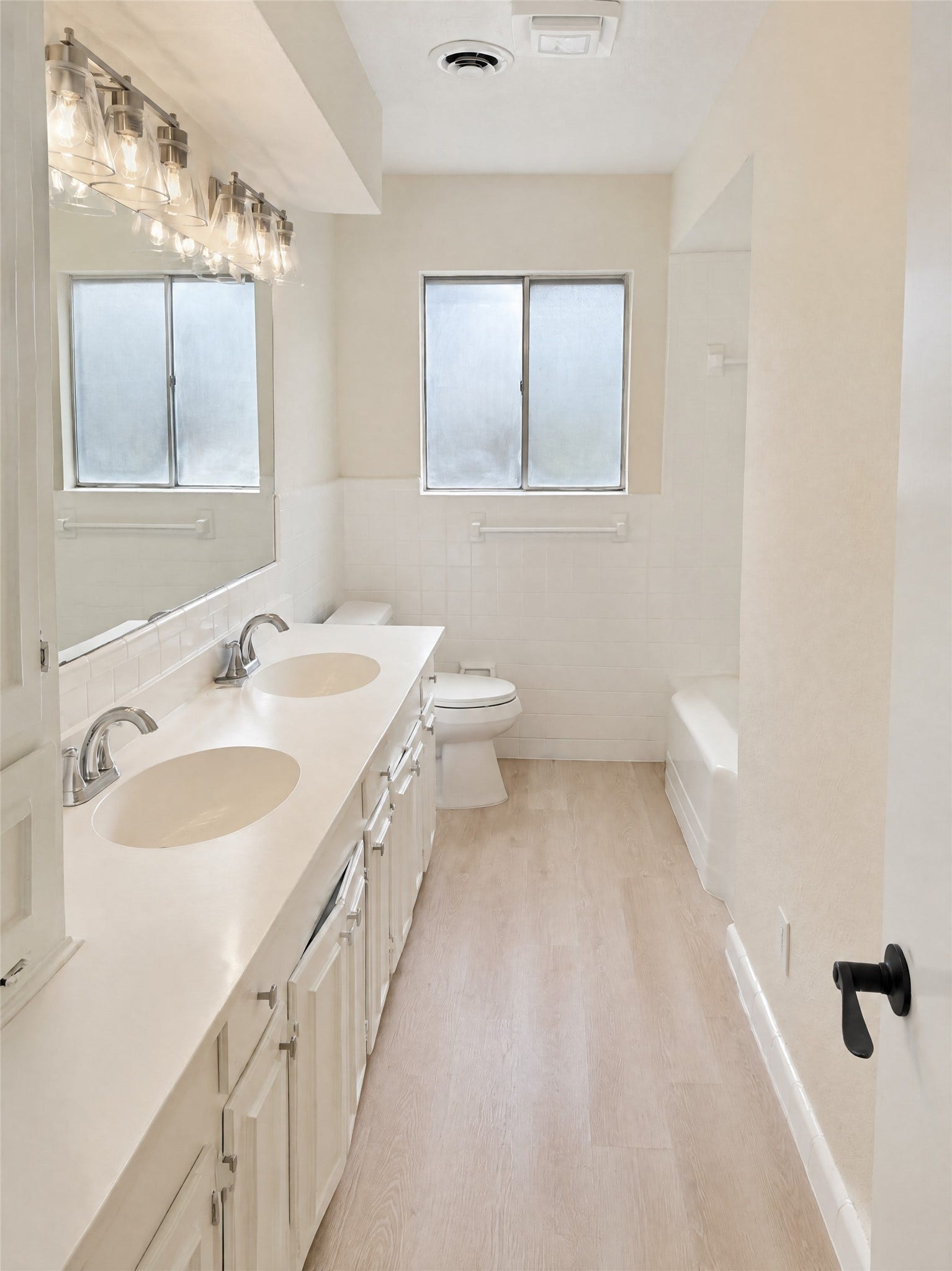 16411 Amcreek Road, Houston, TX 77068 Serving the secondary bedrooms and guests, this full bathroom features an expansive double vanity, framed vanity lighting with vintage-inspired glass shades, pristine white tile surround, and a tub/shower combination.