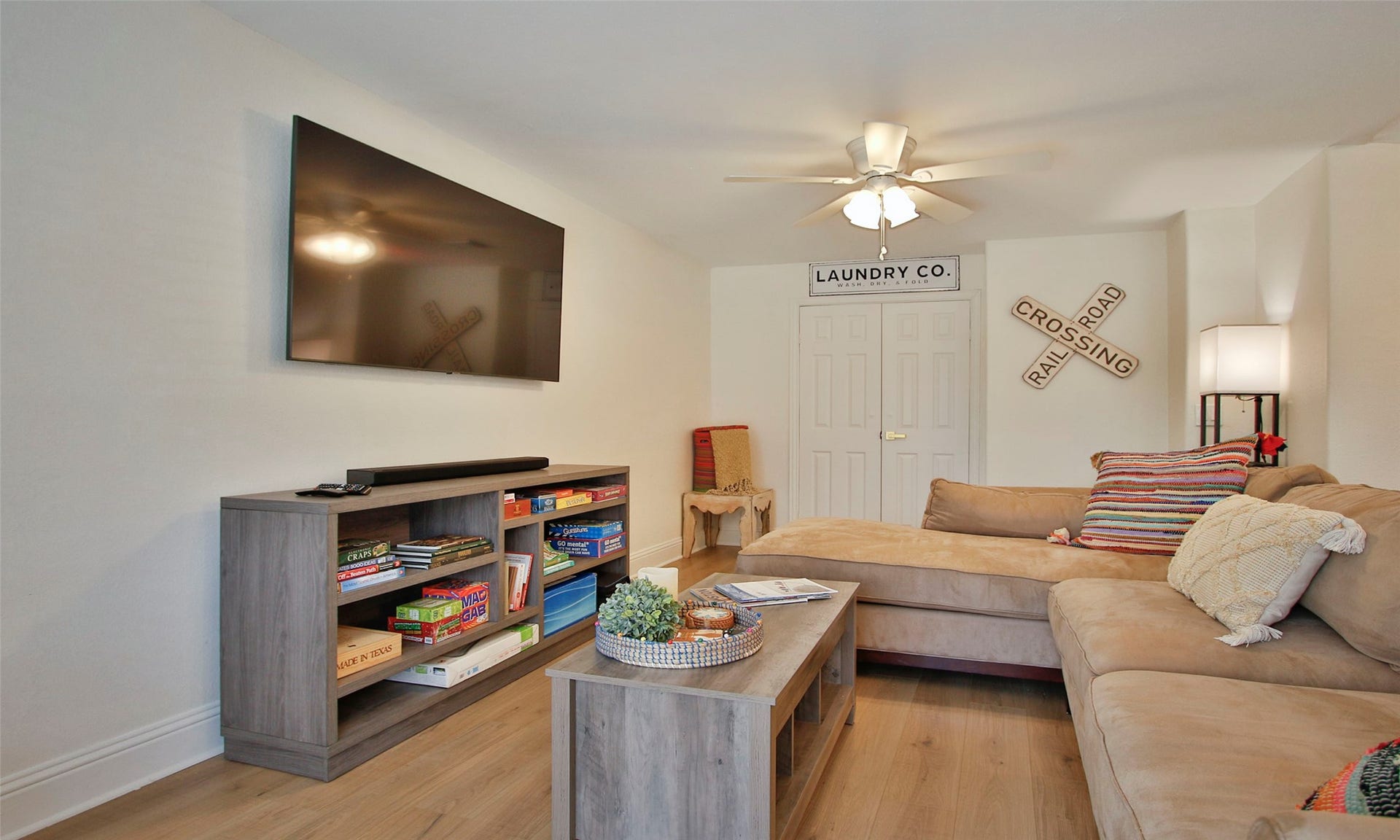 1518 Sabine Street, Houston, TX 77007 The inviting family room offers abundant natural light, luxury vinyl plank flooring, and generous space for relaxing or entertaining. A conveniently located laundry area is discreetly tucked behind folding doors, providing easy access while maintaining a clean, uncluttered appearance.