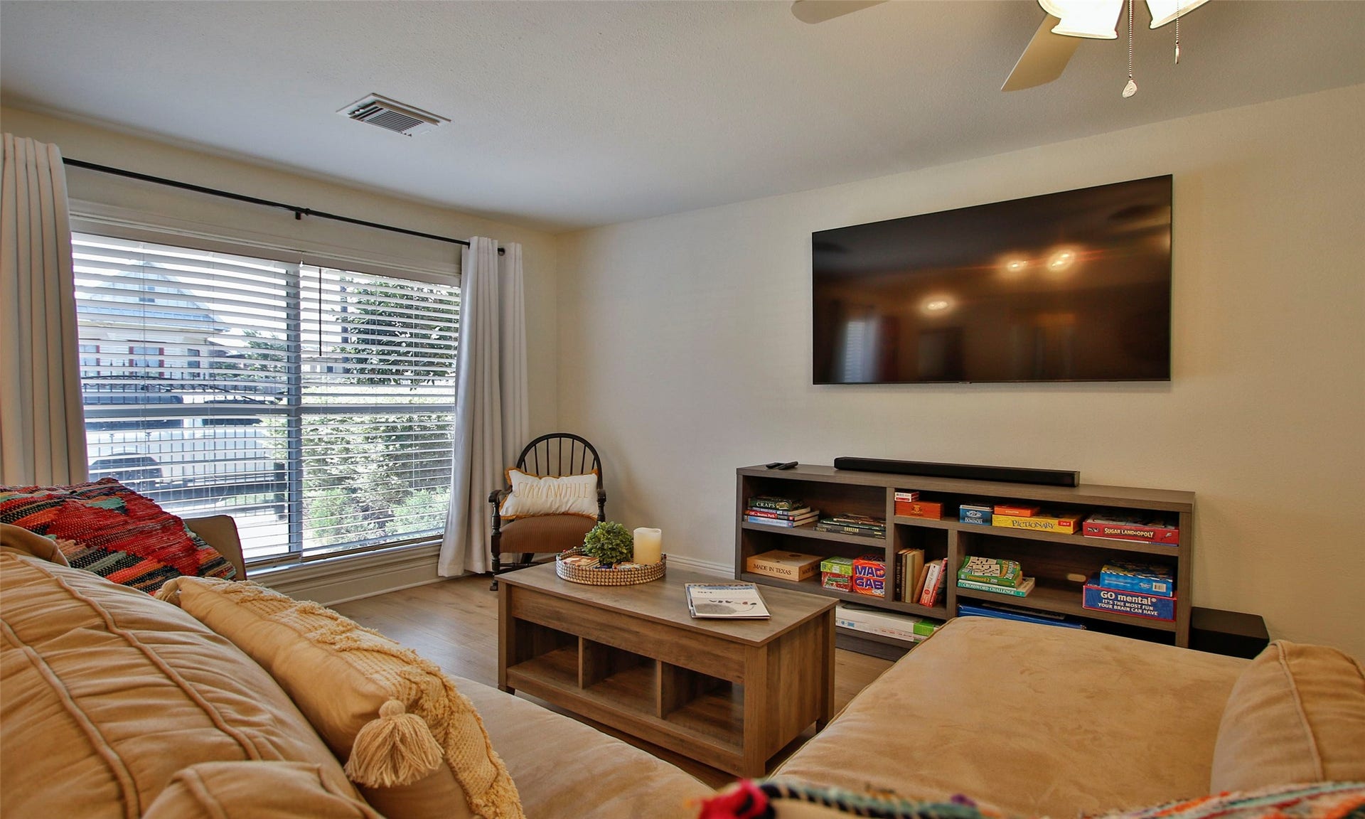1518 Sabine Street, Houston, TX 77007 Another view of the spacious family room highlights the large picture window that fills the space with abundant natural light. This inviting gathering area features luxury vinyl plank flooring and ample room for comfortable seating, movie nights, and everyday living.