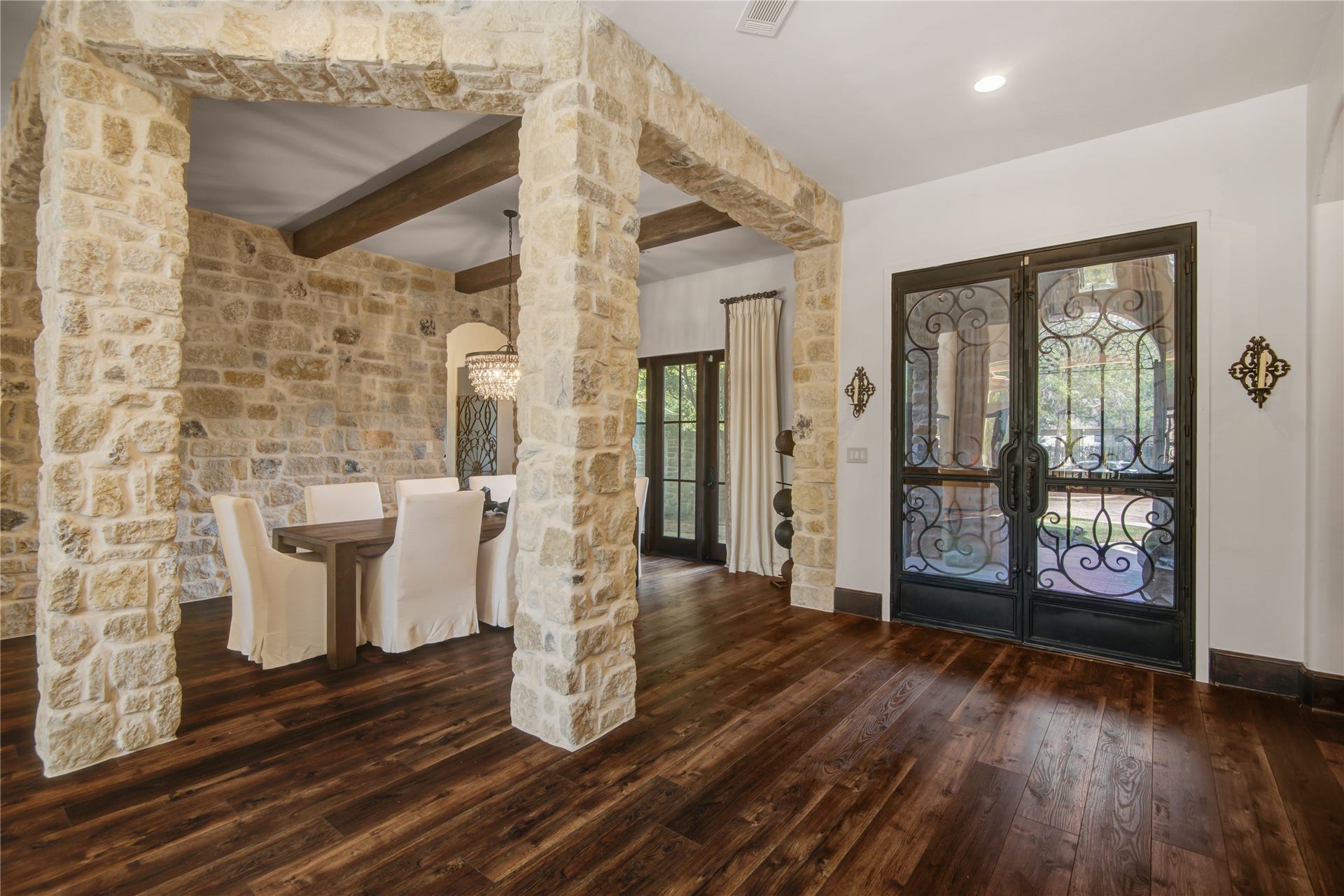 10 Sullivans Lane, Missouri City, TX 77459 Another view of the dining area with rustic stone walls and wood-beamed ceilings, complemented by rich hardwood floors.