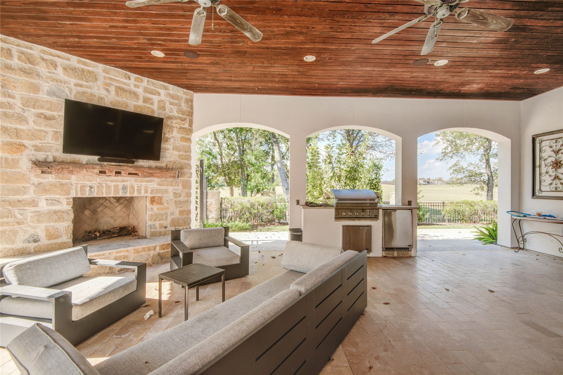 10 Sullivans Lane, Missouri City, TX 77459 Enjoy a spacious covered patio with built-in surround sound, a wood-burning fireplace, multiple fans, elegant travertine, a fully equipped outdoor kitchen, and a mosquito system that extends into the trees.