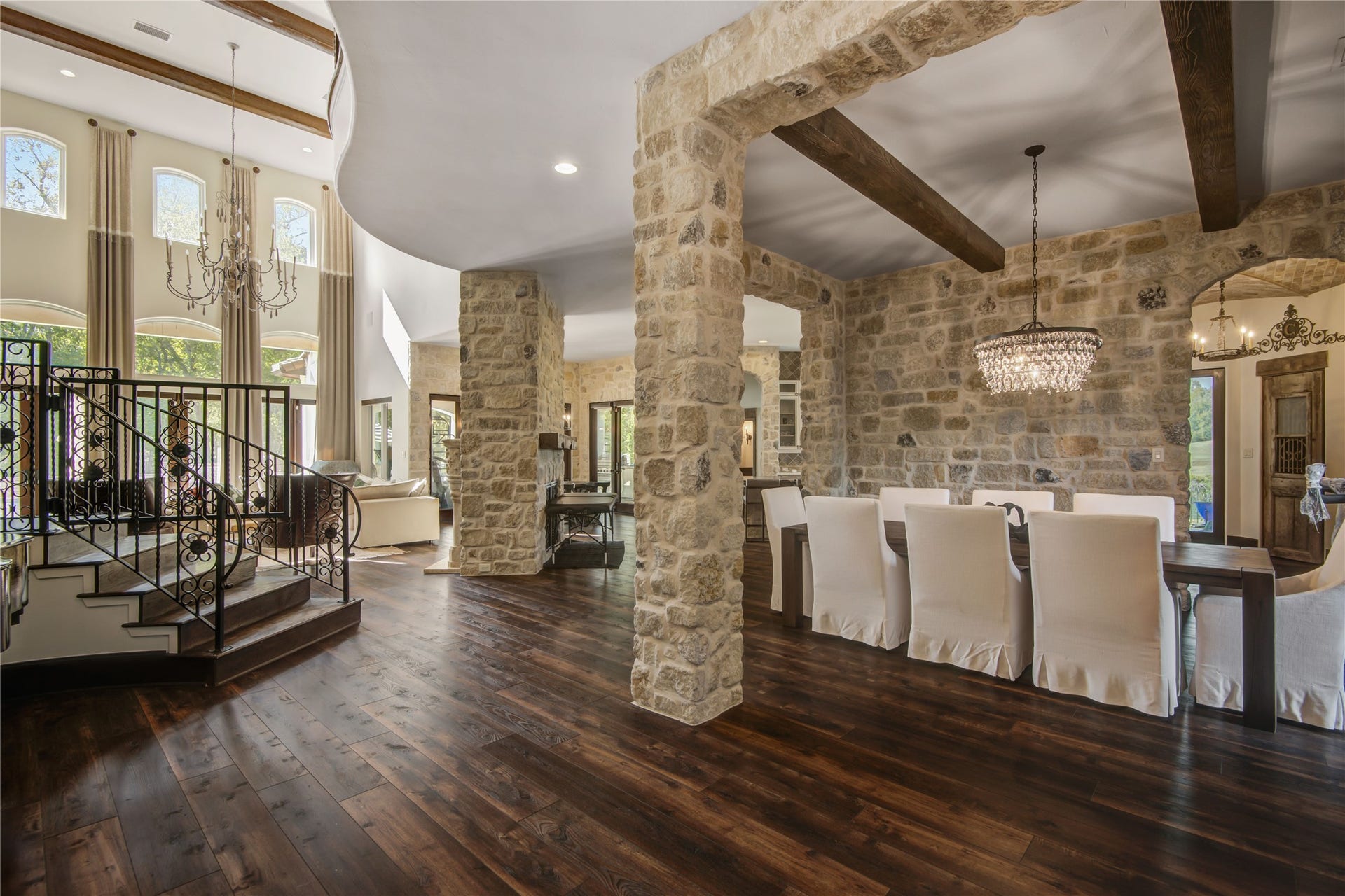 10 Sullivans Lane, Missouri City, TX 77459 A refined, rustic-inspired interior that artfully combines natural materials with high-end design. The space is anchored by striking stone columns and textured stone walls, creating a warm, lodge-like ambiance. Overhead, exposed wooden beams accentuate the rustic charm, while the dark, rich hardwood flooring adds depth, contrast, and an unmistakable touch of luxury.Do you like this personality?