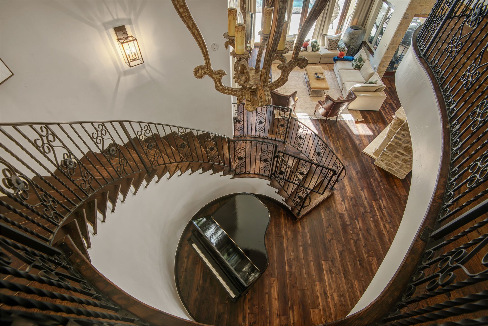 10 Sullivans Lane, Missouri City, TX 77459 Grand spiral staircase with ornate iron railings, leading to the spacious living area. A striking chandelier adds a touch of sophistication.