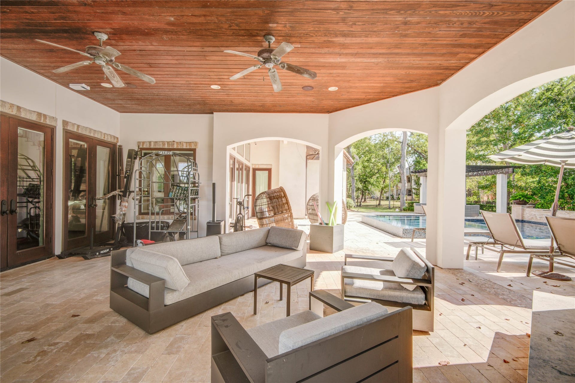 10 Sullivans Lane, Missouri City, TX 77459 The outdoor patio features ceiling fans, and a wood-paneled ceiling that opens up to a spacious backyard.