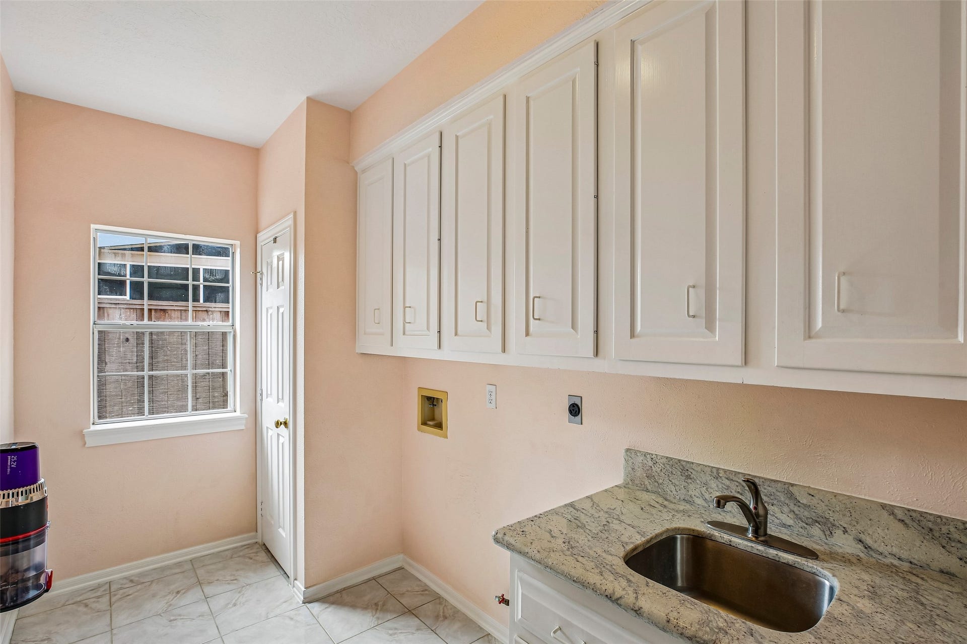 Laundry room is spacious with a utility closet and sink with granit countertop.