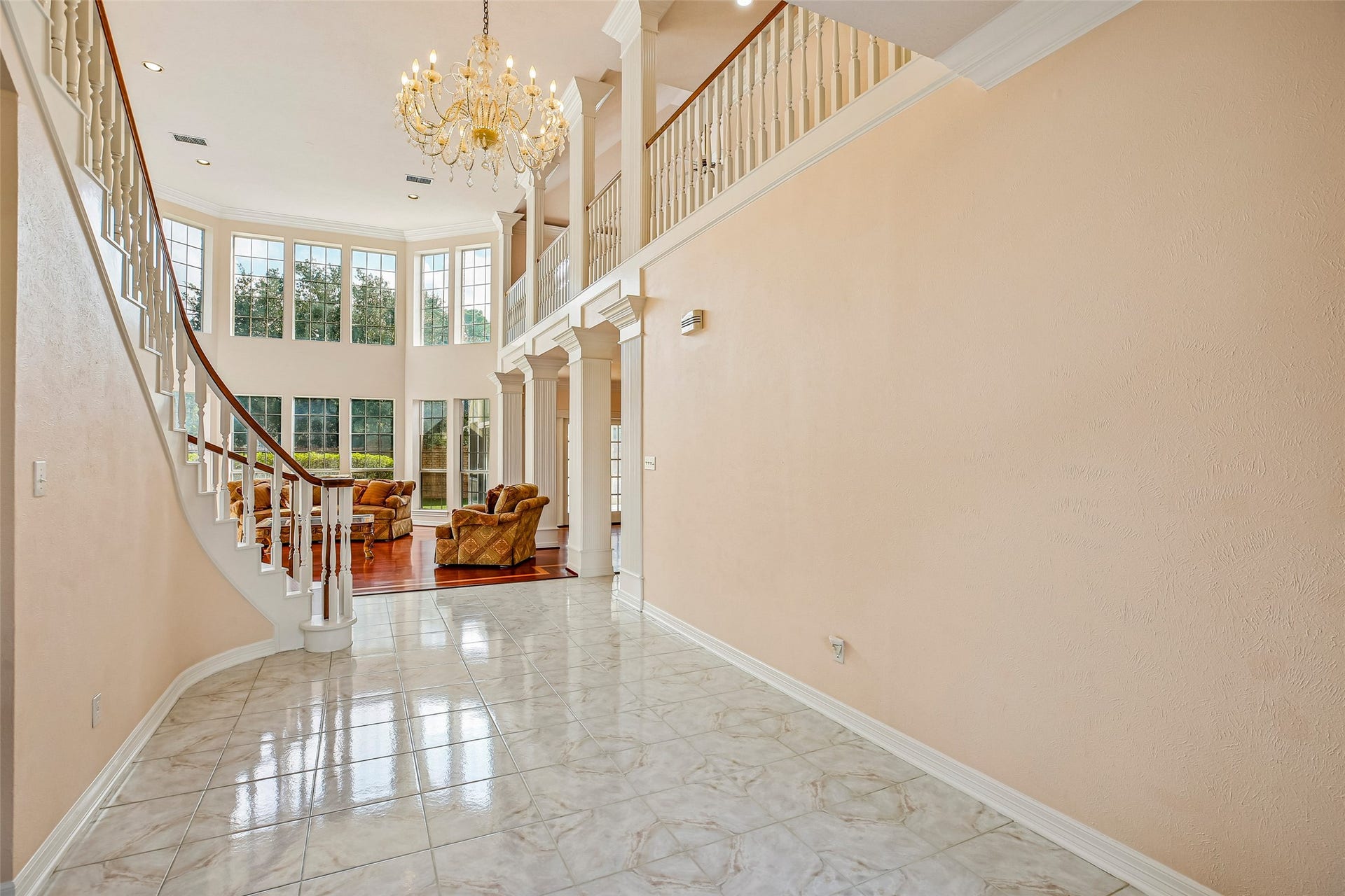 Tiled entryway as you walk-in to high vaulted ceilings and a gorgeous spiral stairway.