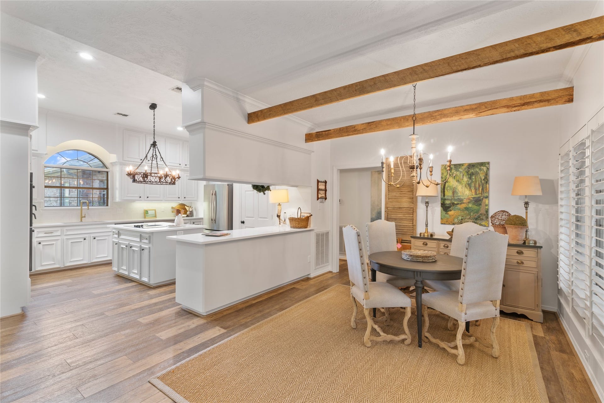 901 Longmire Road, #51, Conroe, TX 77304 Charming open-concept dining and kitchen area featuring rustic wooden beams, elegant chandeliers, and a spacious layout with bright white cabinetry and sleek countertops.