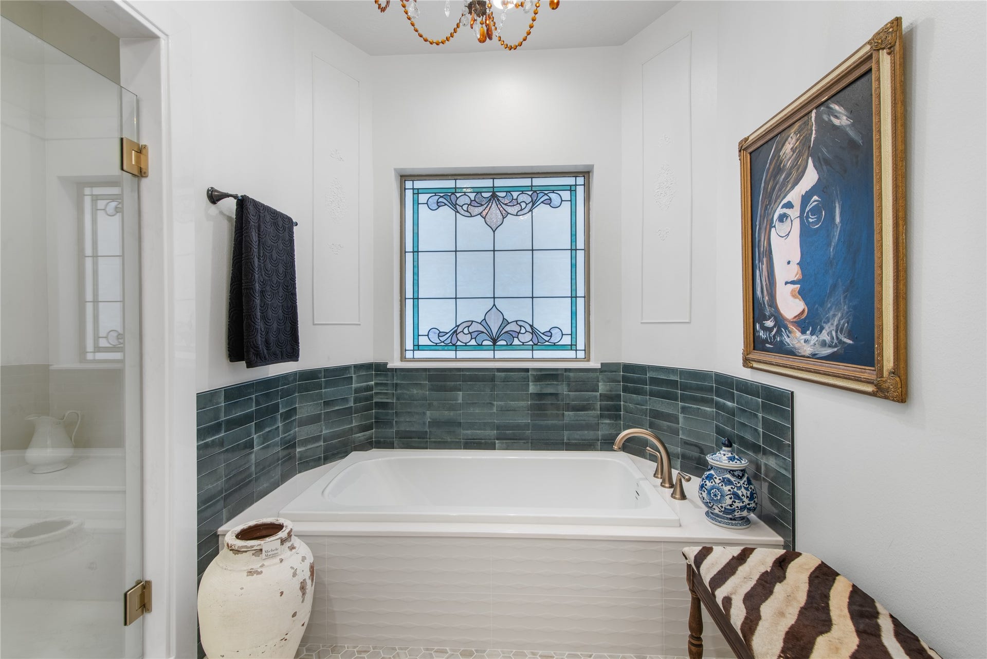 901 Longmire Road, #51, Conroe, TX 77304 Both a shower and luxurious soaking tub with stylish green tile accents, complemented by a decorative stained glass window and unique artwork.