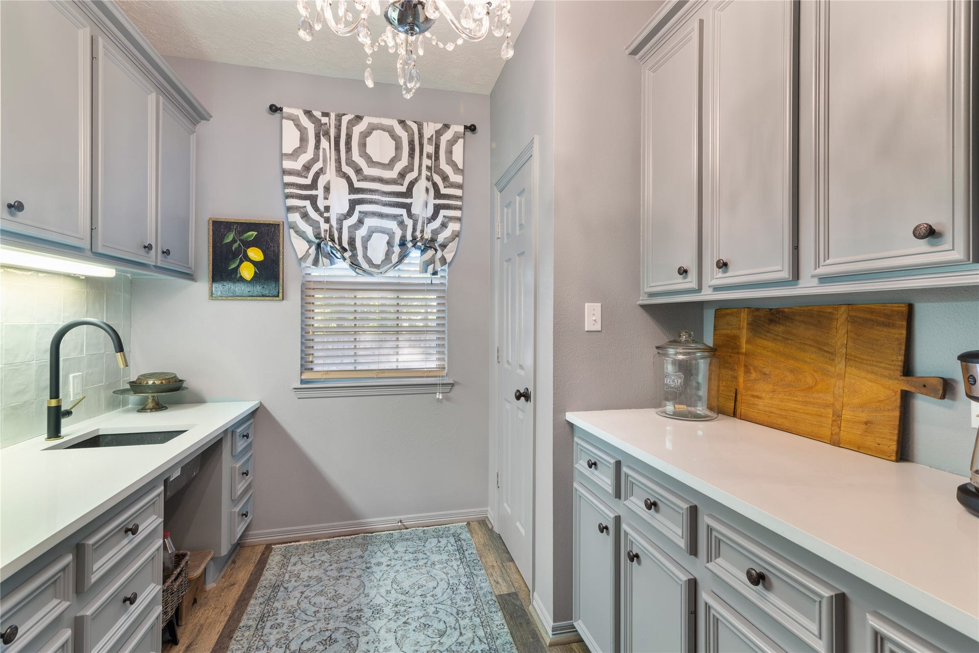 901 Longmire Road, #51, Conroe, TX 77304 Charming kitchen nook with elegant cabinetry, sleek countertops, and a stylish chandelier, complemented by a chic window treatment and modern fixtures.