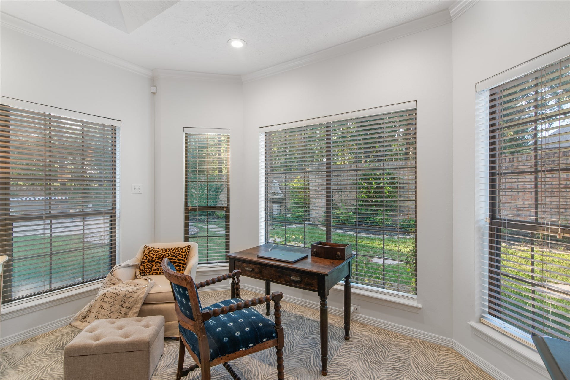 901 Longmire Road, #51, Conroe, TX 77304 Bright and inviting home office space with large windows offering serene garden views, featuring elegant furnishings and ample natural light.