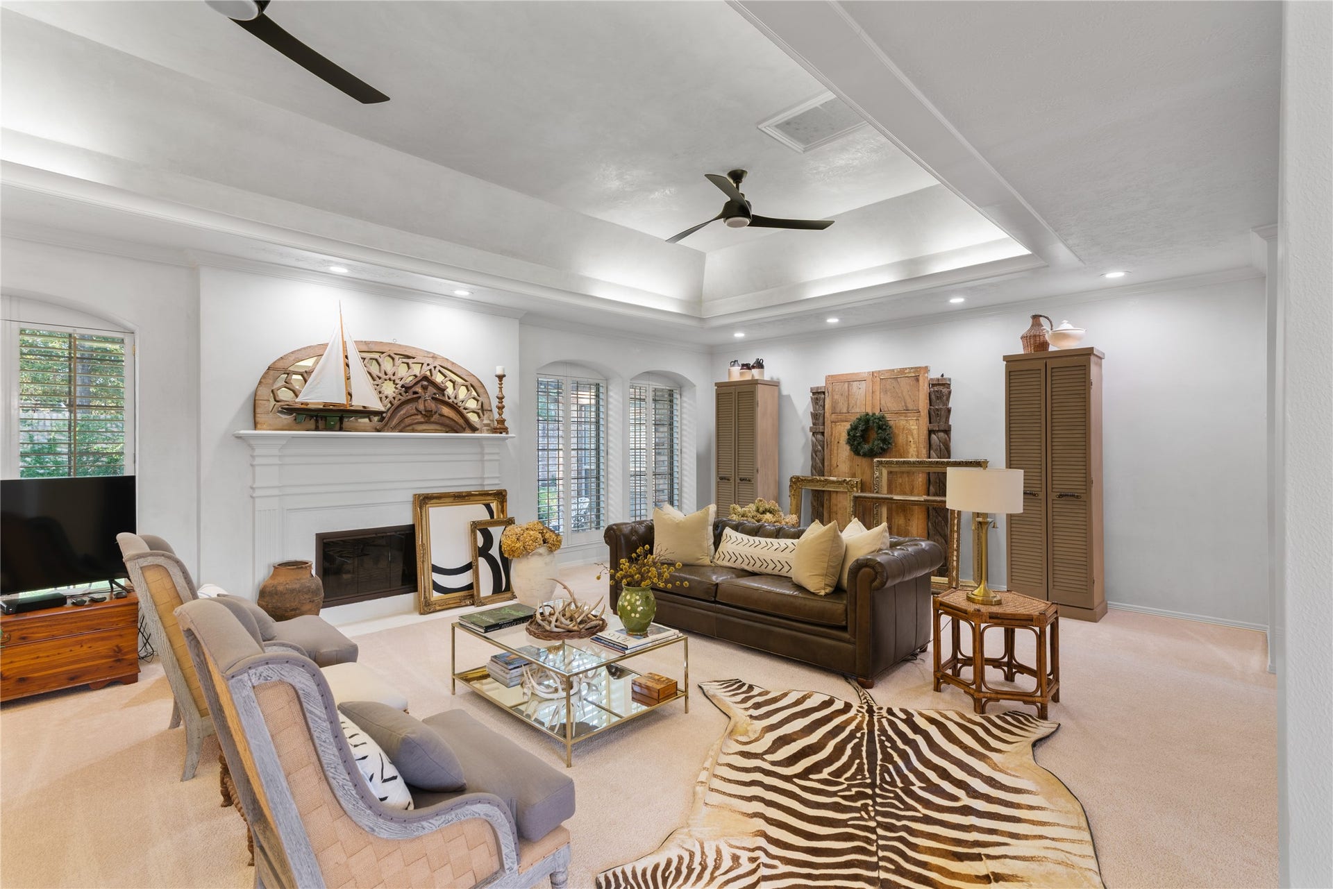 901 Longmire Road, #51, Conroe, TX 77304 Spacious living room featuring a cozy fireplace, elegant coffered ceiling, and a blend of traditional and modern decor with ample natural light.