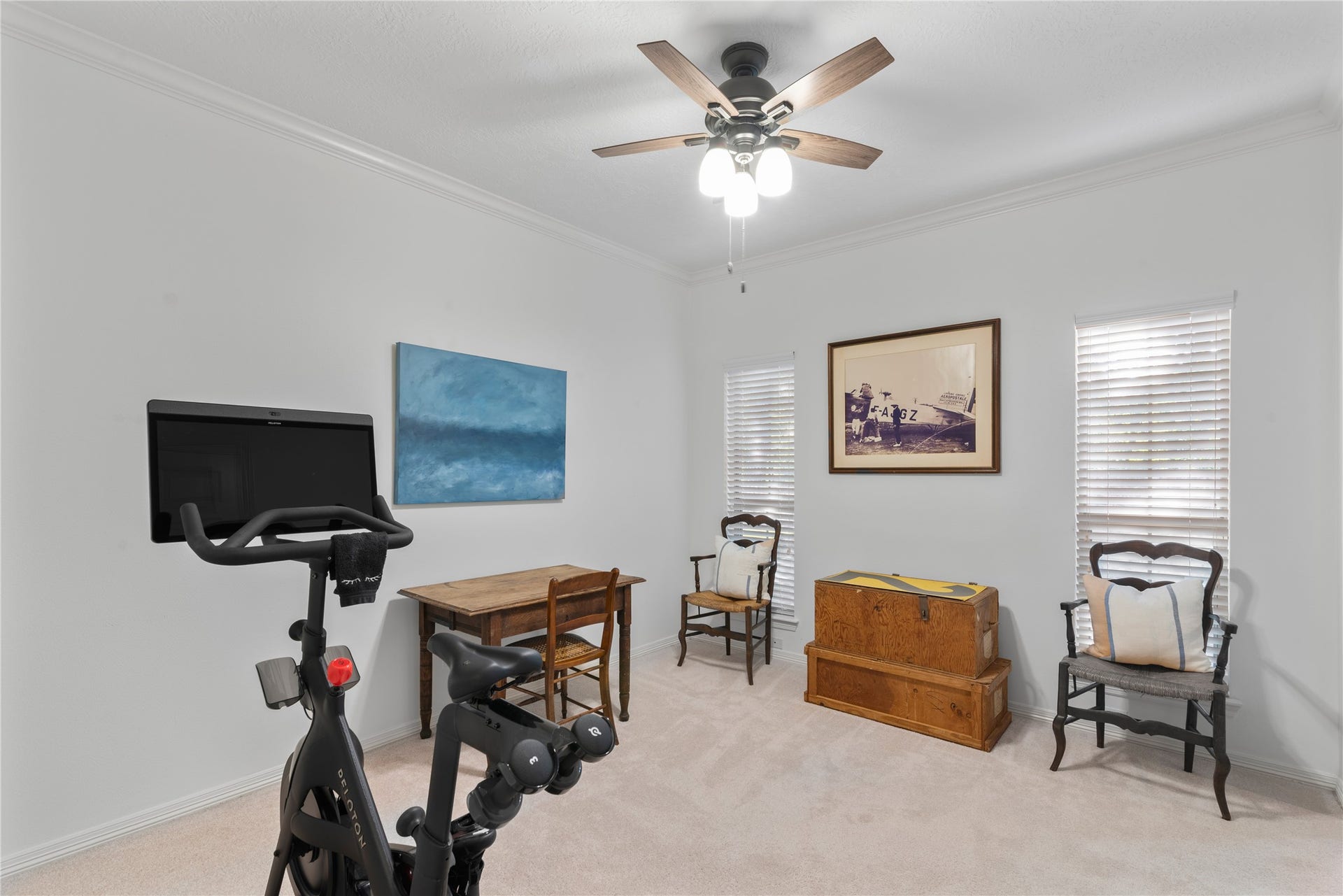 901 Longmire Road, #51, Conroe, TX 77304 Bright and versatile room featuring a ceiling fan, exercise bike, and cozy seating area, perfect for a home office or workout space.