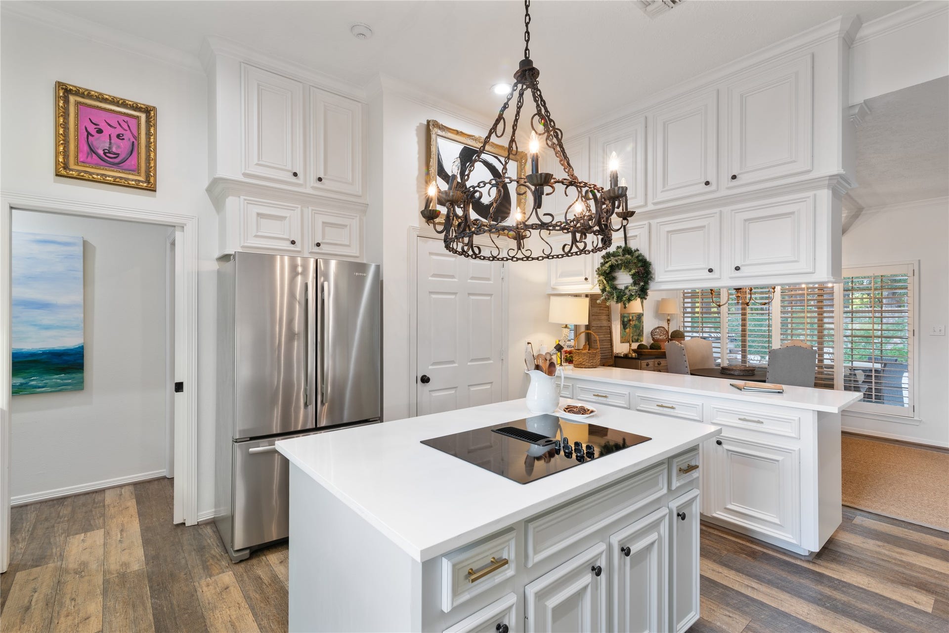 901 Longmire Road, #51, Conroe, TX 77304 Bright and inviting kitchen with modern stainless steel appliances, elegant white cabinetry, and a stylish chandelier above a spacious island.