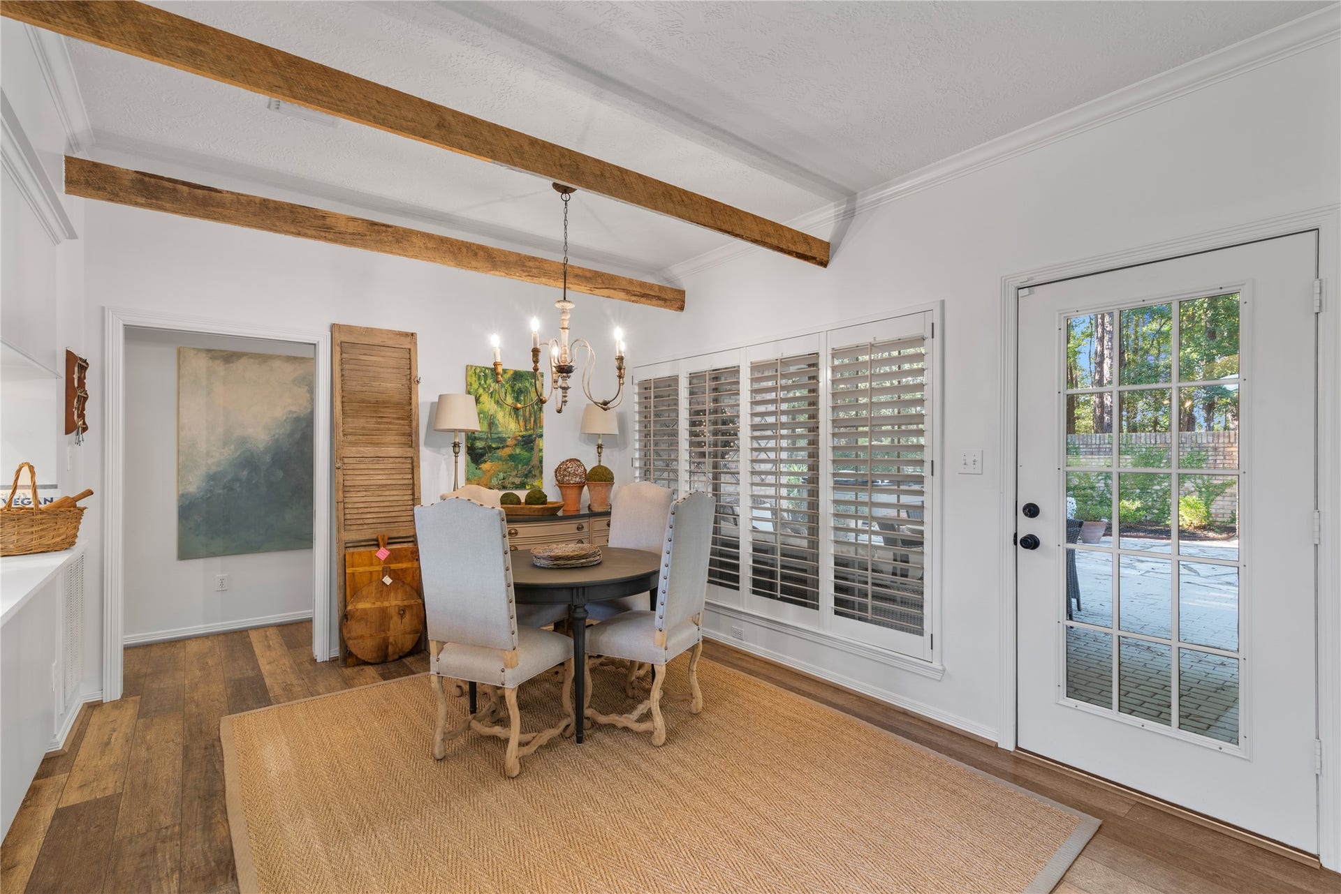 901 Longmire Road, #51, Conroe, TX 77304 Charming dining area with rustic wood beams, elegant chandelier, and abundant natural light from large windows and a glass door leading to the patio.