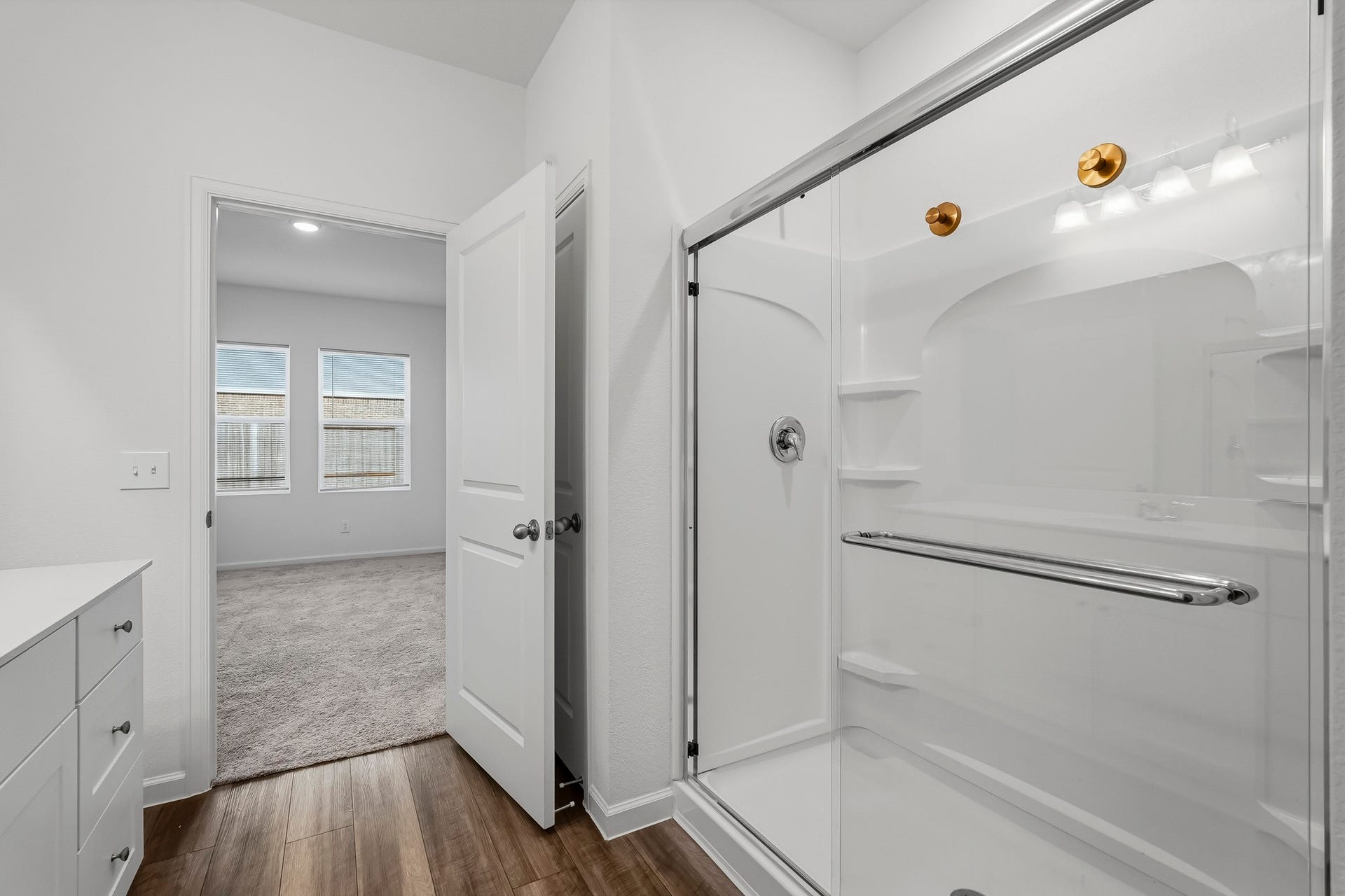 21547 Rolling Streams Drive, New Caney, TX 77357 The glass-enclosed walk-in shower features sleek sliding doors and built-in shelving for added convenience.