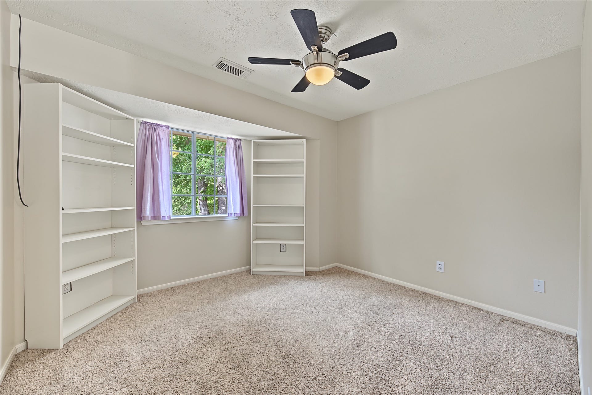 2302 Piney Woods Drive, Pearland, TX 77581 Secondary Bedroom 1 with a ceiling fan, natural light, and shelving on both sides of the window