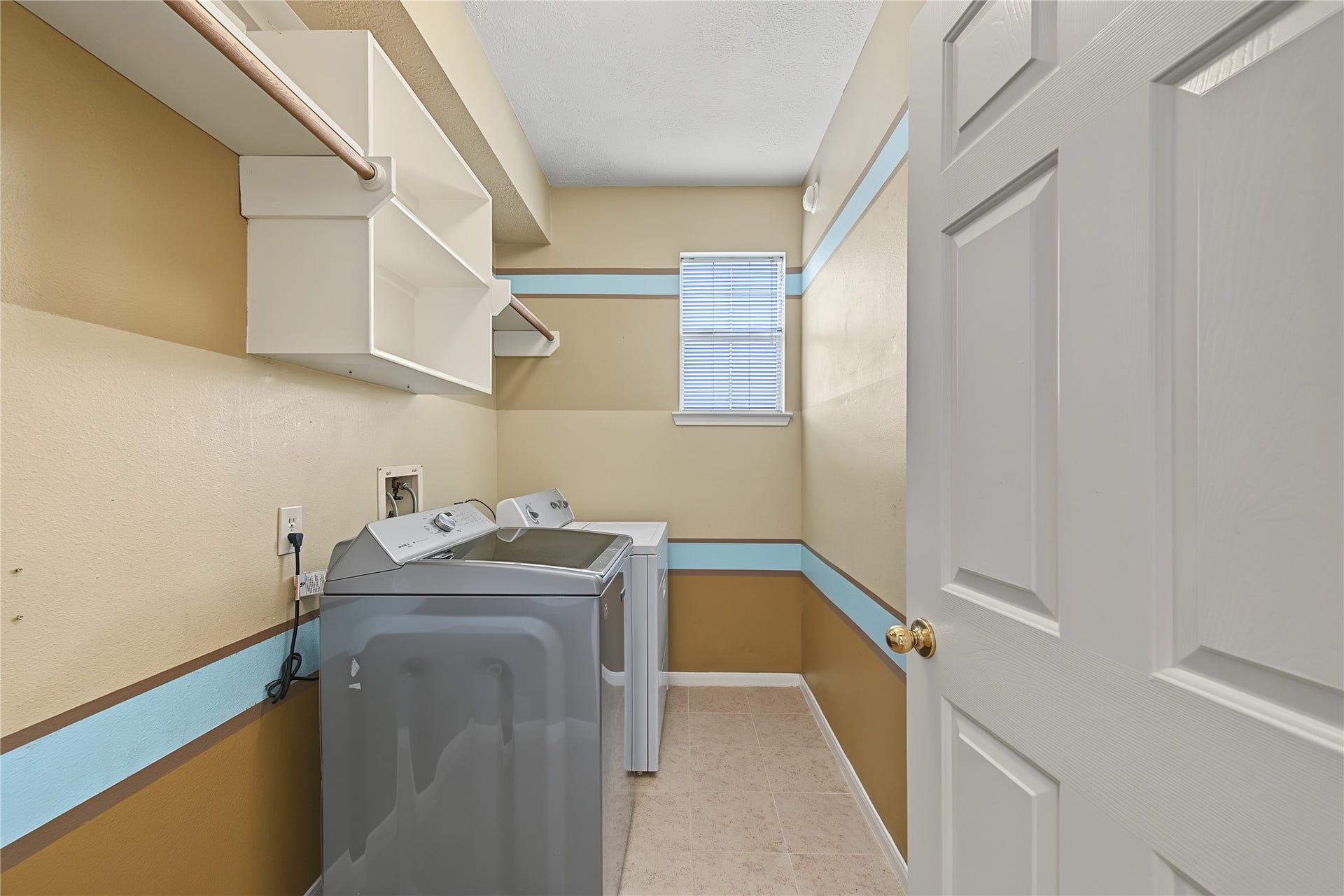 2302 Piney Woods Drive, Pearland, TX 77581 Utility room with built-in shelving, hanging space, and natural light