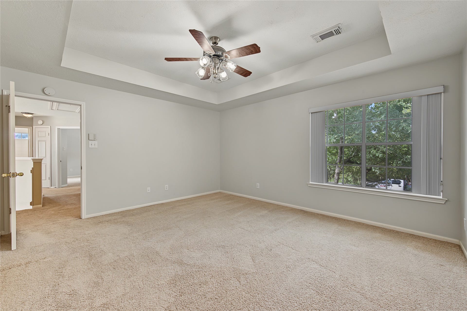 2302 Piney Woods Drive, Pearland, TX 77581 A lovely, generously sized primary suite with a tray ceiling, ceiling fan, and backyard view