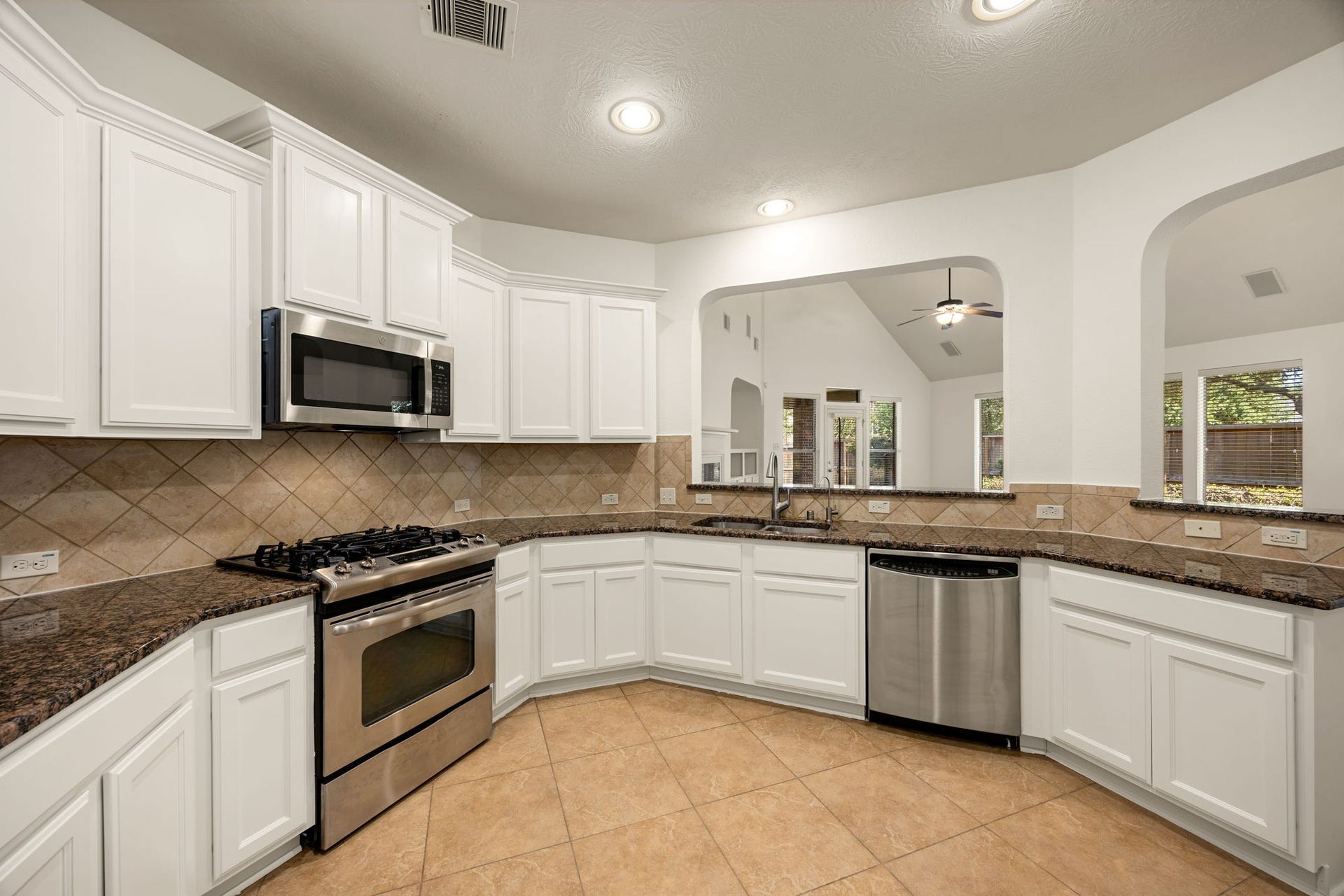 9430 Amethyst Arbor Lane, Katy, TX 77494 Positioned perfectly at the very center of the home, this unique circular kitchen offers a highly functional, wrapping design that serves as the ultimate hub for daily life. The sleek stainless steel gas range and matching built-in microwave provides modern cooking efficiency.
