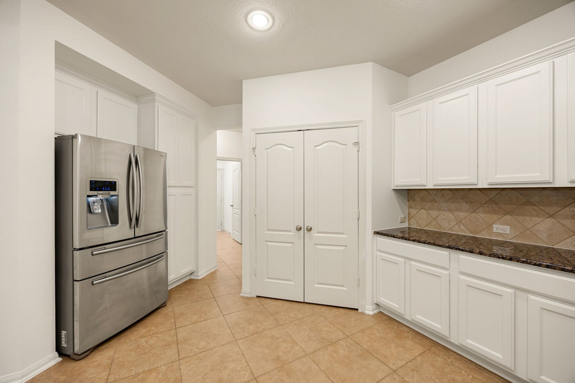 9430 Amethyst Arbor Lane, Katy, TX 77494 Completing the circular kitchen layout, this final angle highlights an expansive double-door pantry alongside a generous built-in serving station.