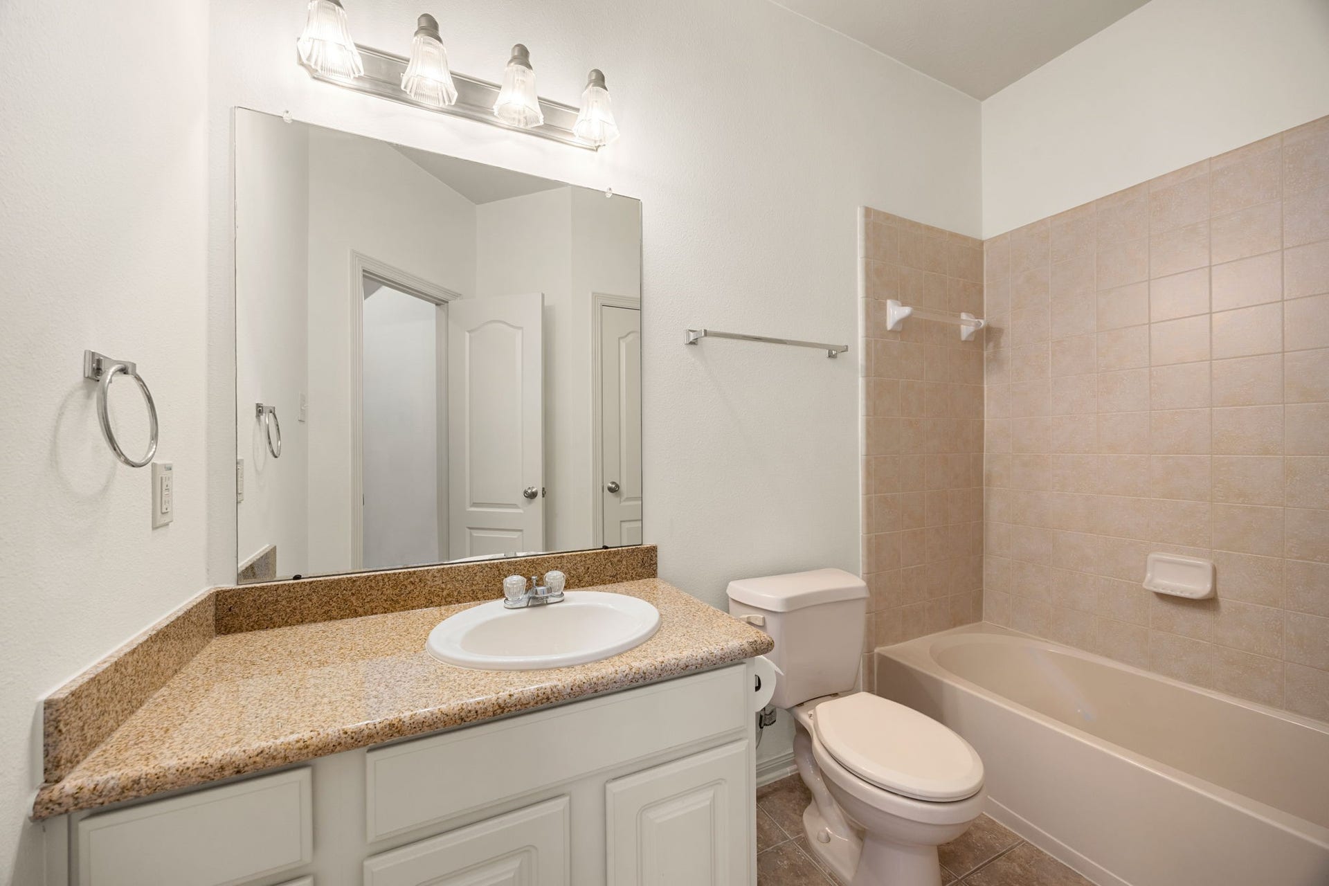 9430 Amethyst Arbor Lane, Katy, TX 77494 Conveniently located directly adjacent to the upstairs game room, this full secondary bathroom features a highly functional layout anchored by a spacious single vanity with neutral granite countertops.