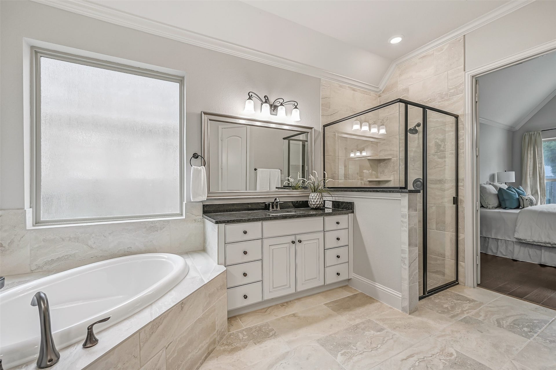 1640 Longwood Glen Lane, Friendswood, TX 77546 Just off the primary bedroom, the generously sized bathroom features a corner soaking tub beneath a large privacy-glass window, separate glass-enclosed shower with tiled surround & two individual granite-topped vanities. Coordinating stone-look tile flooring ties everything together.