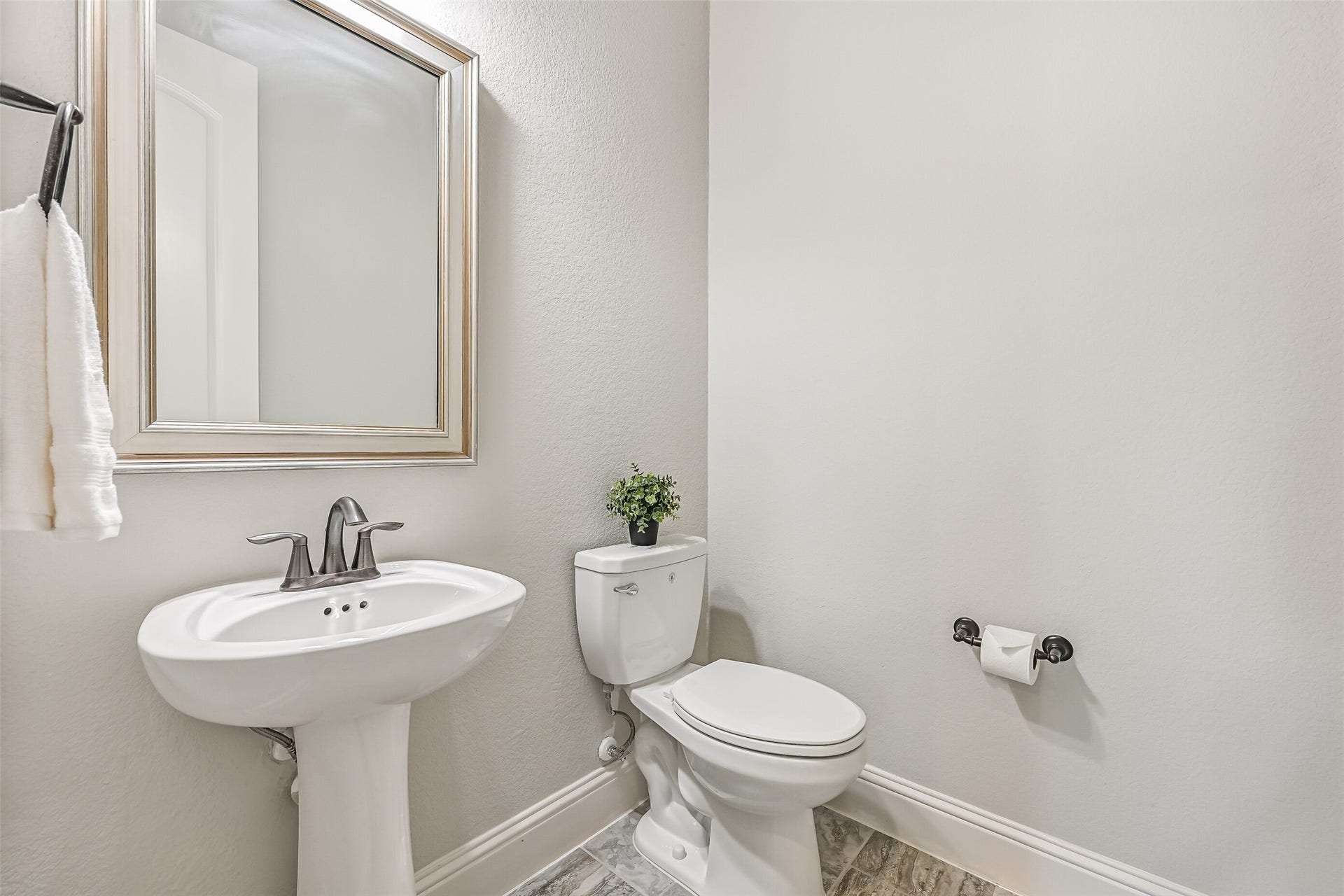 1640 Longwood Glen Lane, Friendswood, TX 77546 Just off the foyer, near the garage entrance and staircase, you'll find a convenient half bath with a pedestal sink, framed mirror & stone-look tile flooring.