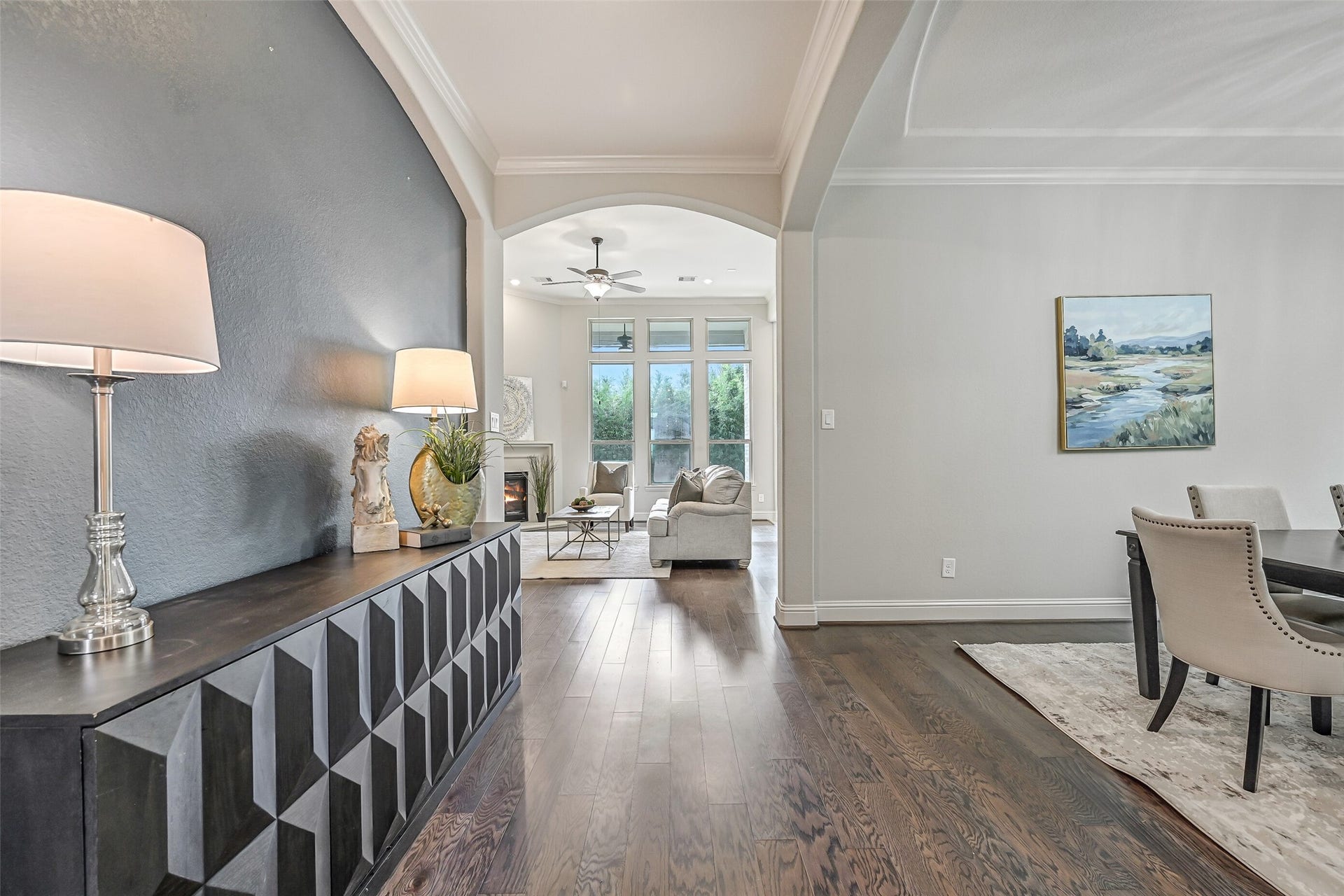 1640 Longwood Glen Lane, Friendswood, TX 77546 From the dining room, the wide arched opening draws you toward the family room beyond. Continuous luxury vinyl plank flooring connects the spaces, while the recessed accent wall adds architectural interest along the way.