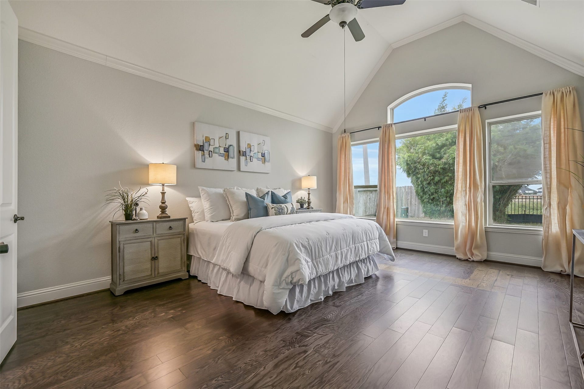 1640 Longwood Glen Lane, Friendswood, TX 77546 The spacious first-floor primary suite feels especially inviting with its dramatic 14' vaulted ceiling, rich luxury vinyl plank flooring & beautiful arrangement of rear-facing windows topped by an arched transom. Crown molding & a lighted ceiling fan add the finishing touches.