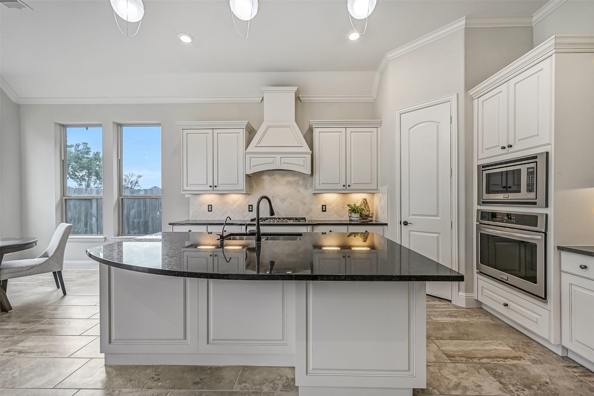 1640 Longwood Glen Lane, Friendswood, TX 77546 The oversized granite island is the centerpiece of this beautiful kitchen, offering plenty of prep space, seating & additional cabinetry. Crisp white cabinetry, custom pendant lighting, a decorative vent hood & built-in stainless appliances create a polished, coordinated look.