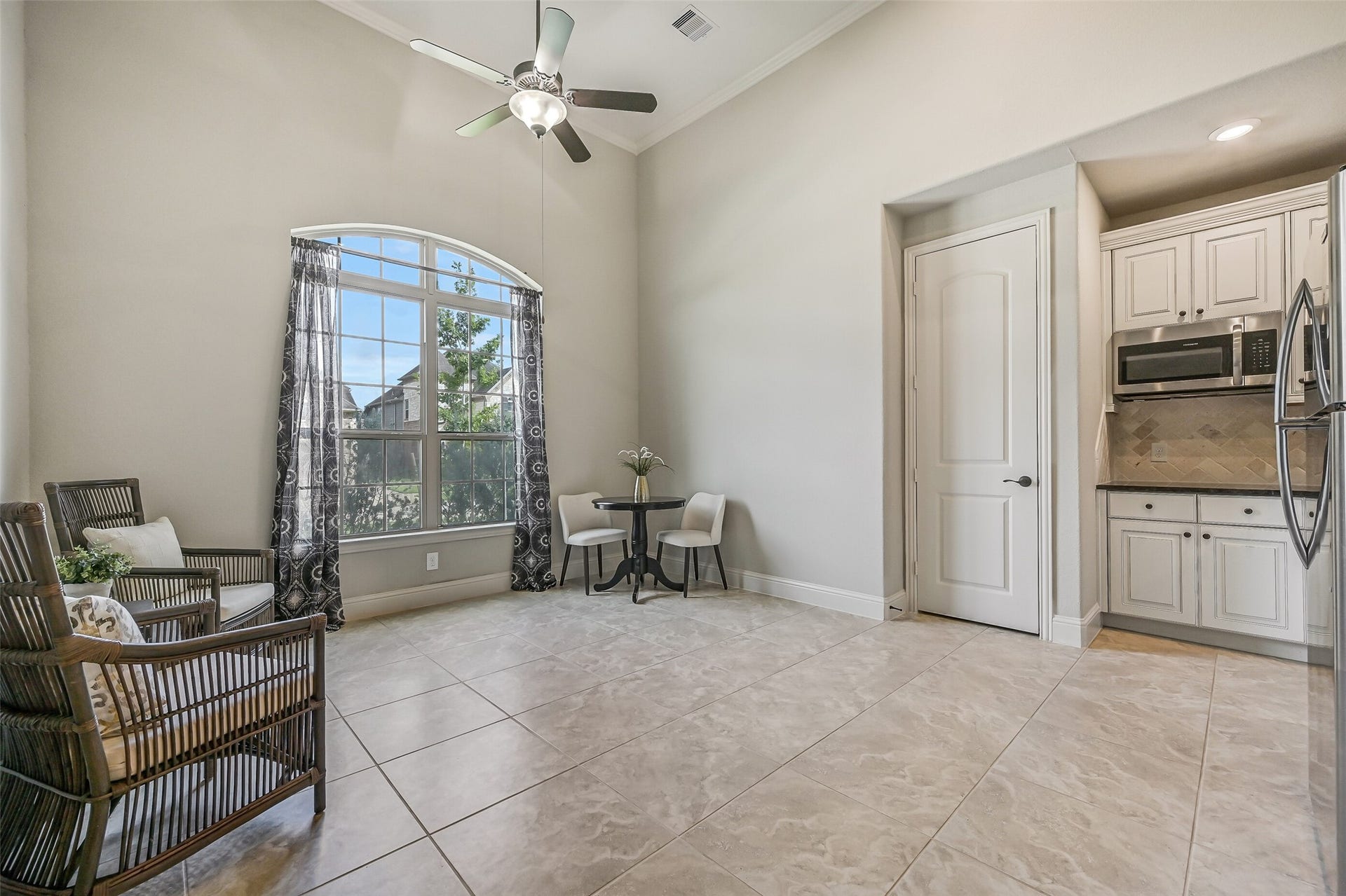 1640 Longwood Glen Lane, Friendswood, TX 77546 The apartment's spacious living area features a soaring 14' ceiling, crown molding, tile flooring & a lighted ceiling fan. A large arched window welcomes natural light, while the nearby kitchenette makes this a comfortable, self-contained living space. The door beside the kitchenette opens to a utility closet with connections for a stackable washer & dryer.