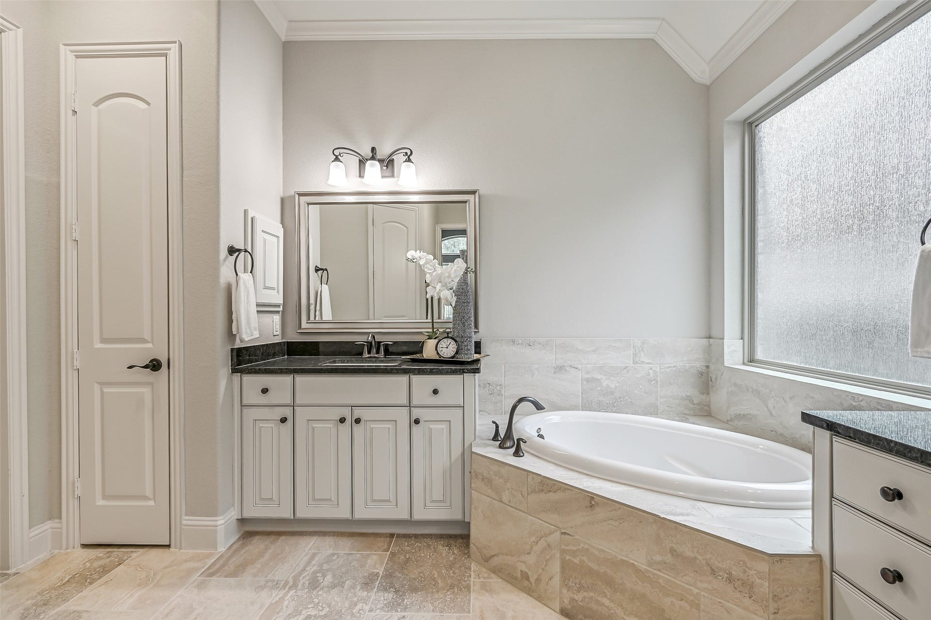 1640 Longwood Glen Lane, Friendswood, TX 77546 Another look at the primary bath highlights the second granite-topped vanity, framed mirror & inviting soaking tub with its tiled surround. A generous walk-in closet provides plenty of room for wardrobe storage.