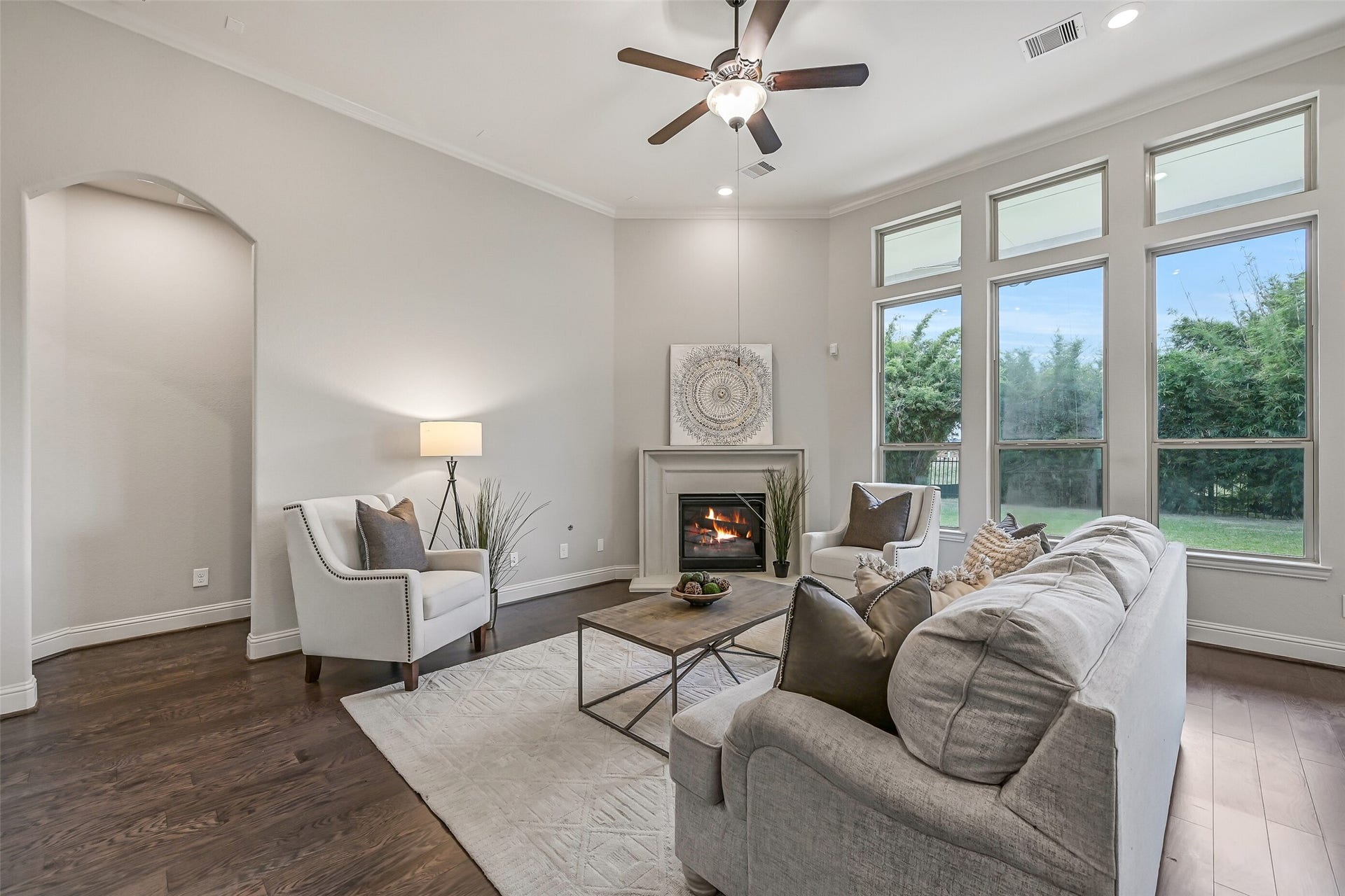1640 Longwood Glen Lane, Friendswood, TX 77546 Another look at the welcoming family room, where the cast-stone gas-log fireplace anchors the space and tall windows bring in beautiful natural light. Rich luxury vinyl plank flooring, crown molding & a lighted ceiling fan complete the room.