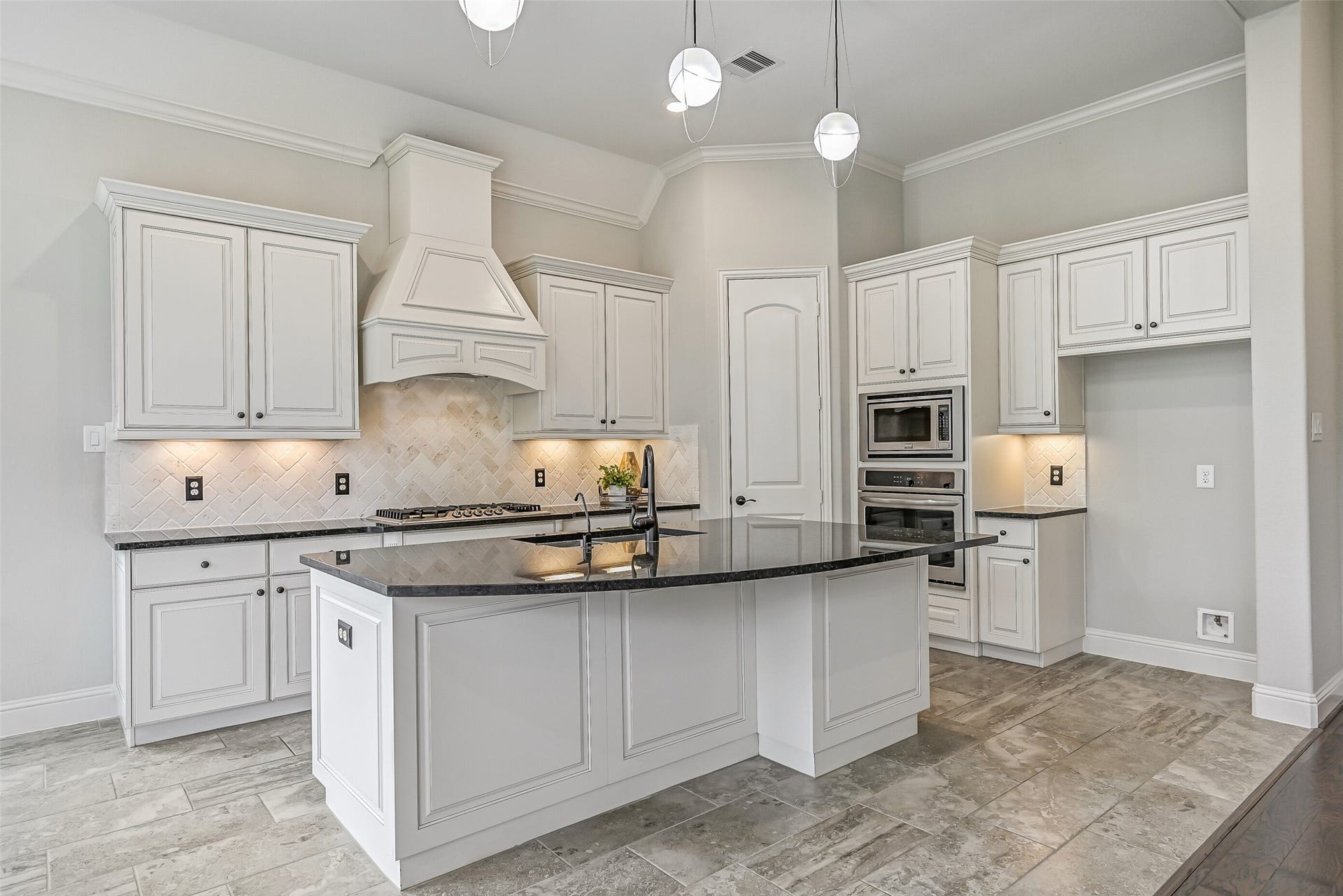 1640 Longwood Glen Lane, Friendswood, TX 77546 The kitchen is a stunner! An oversized granite island takes center stage, surrounded by inked white cabinetry, a herringbone brick backsplash, custom pendant lighting & undercabinet illumination. You'll also find a 5-burner gas cooktop, built-in appliances & a walk-in pantry.