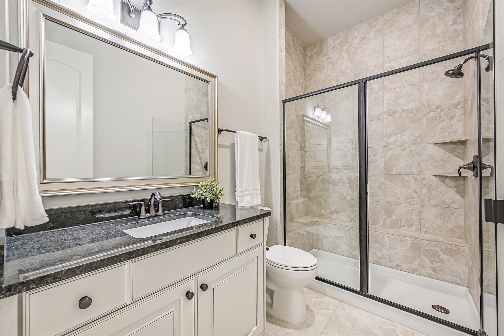 1640 Longwood Glen Lane, Friendswood, TX 77546 The apartment enjoys its own full bathroom with a granite-topped vanity, framed mirror, tile flooring & a glass-enclosed walk-in shower with tiled surround, built-in shaving ledge & corner shelving. Conveniently accessible from the living area as well as the bedroom.