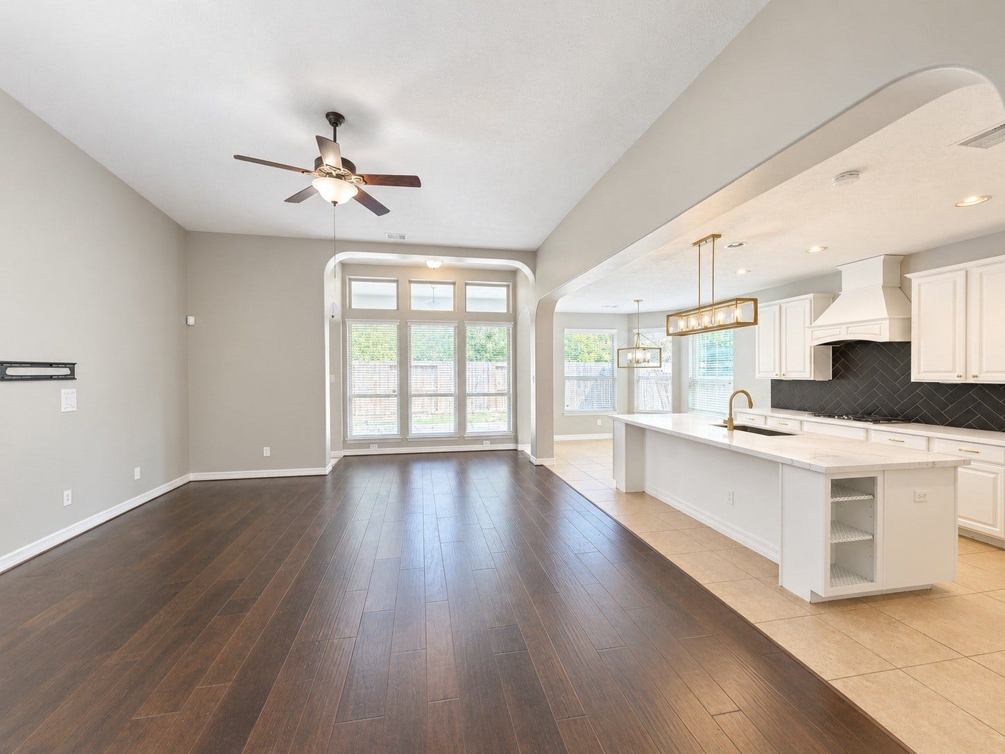 The open-concept living room and remodeled kitchen flow seamlessly together, featuring rich hardwood floors, an oversized island and a wall of windows that fills the space with natural light. Perfect for everyday living and entertaining.