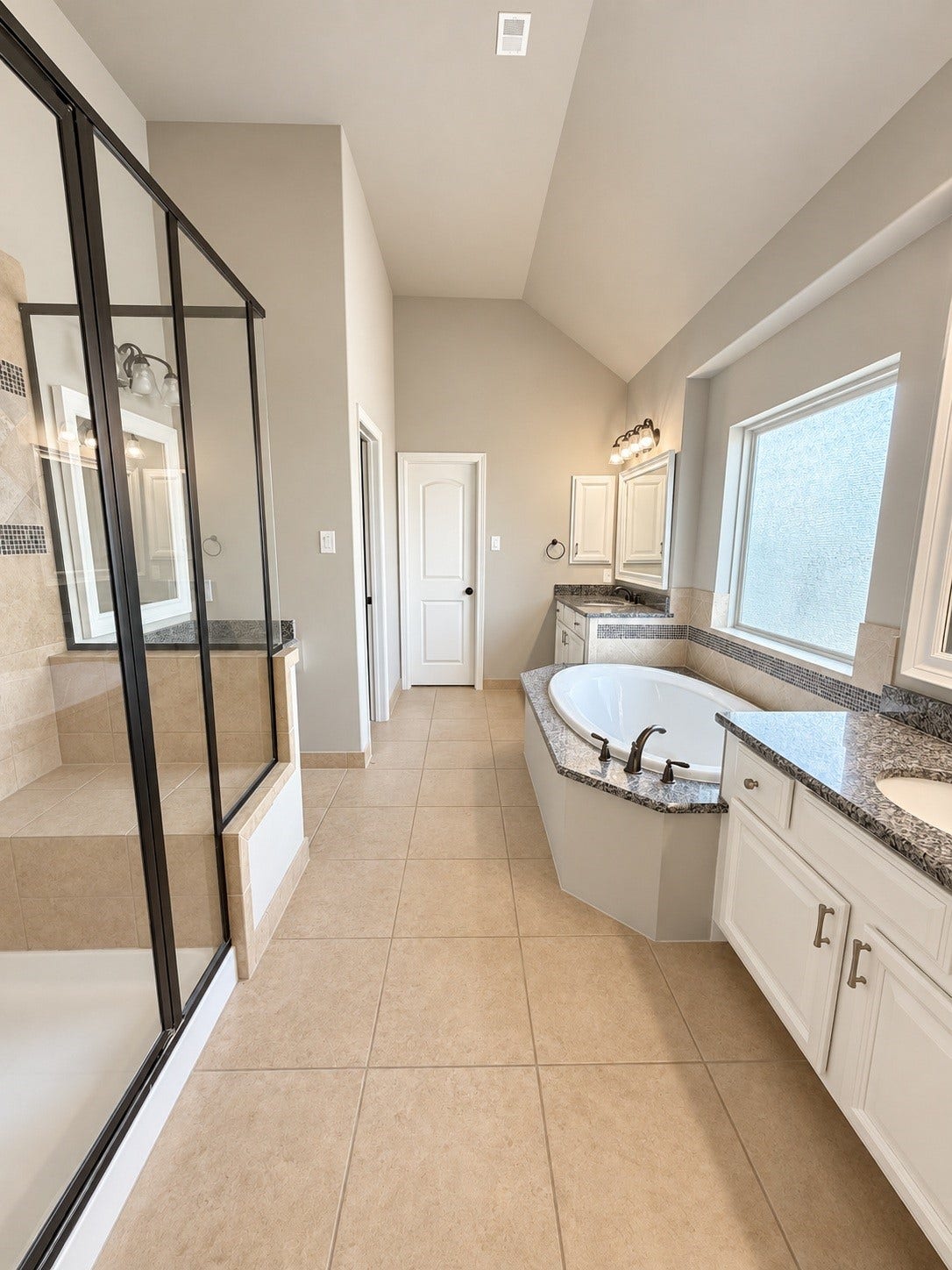 A spa-inspired primary bathroom with soaking tub, dual vanities and shower