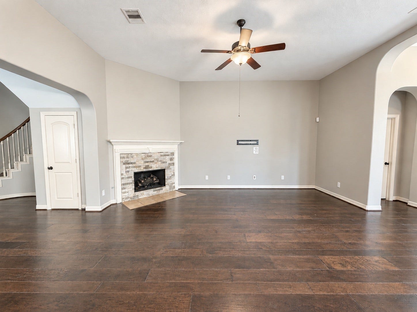 Warm hardwood floors and a striking AirStone fireplace bring character and style to this spacious living room, creating an inviting space for everyday living and entertaining.