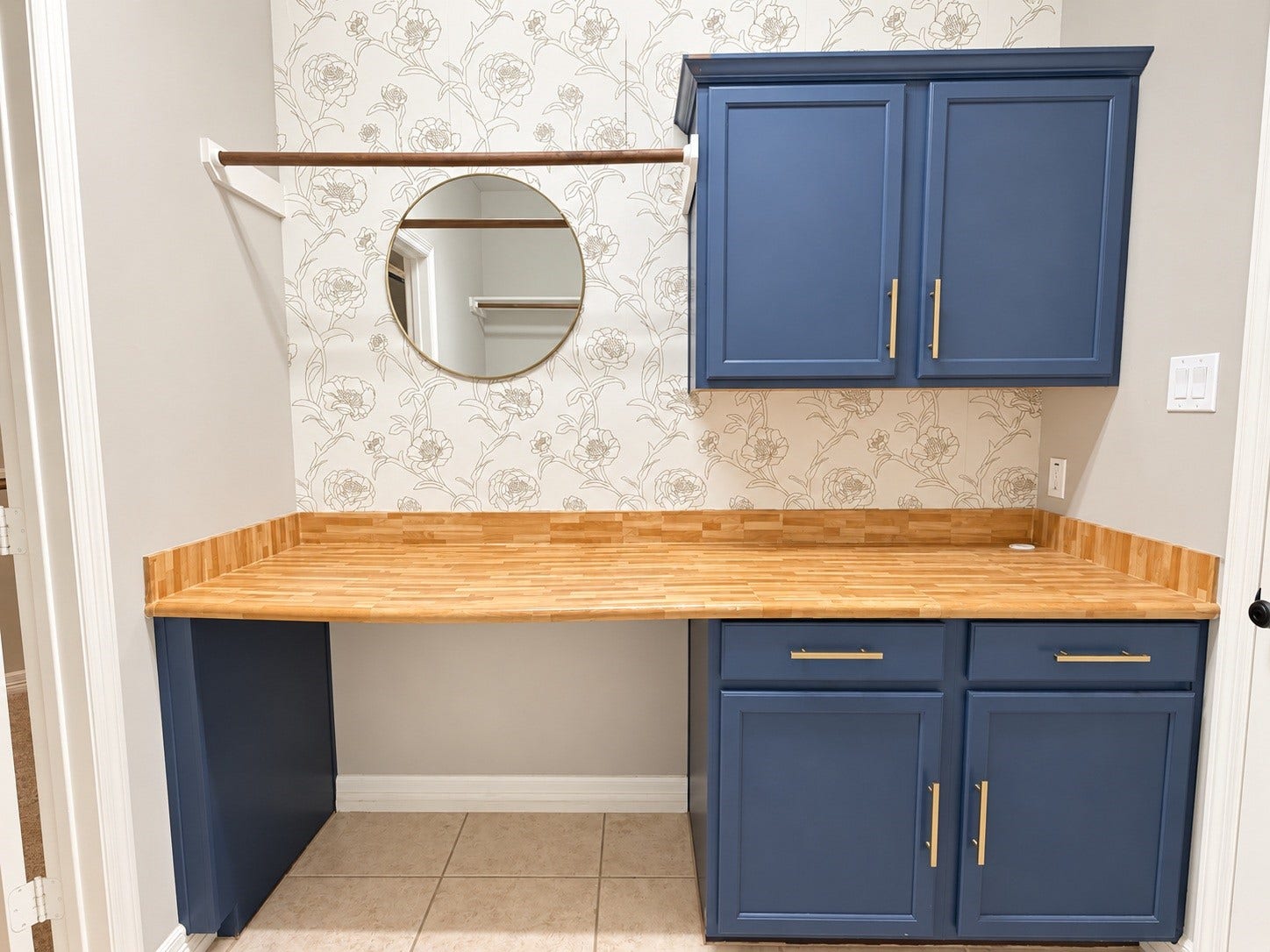 Laundry room of your dream. Beautiful cabinets, countertop and wallpaper.