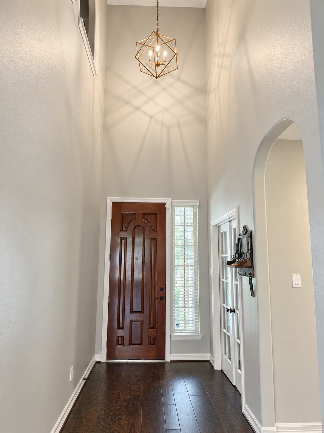 Step inside to a breathtaking two-story foyer with soaring ceilings and a distinctive statement light fixture