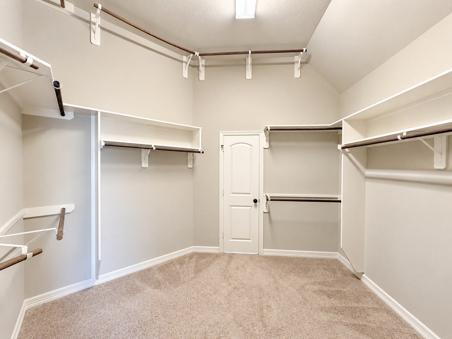 Generous primary walk-in closet offers ample storage and organization, with convenient direct access to the remodeled utility room.