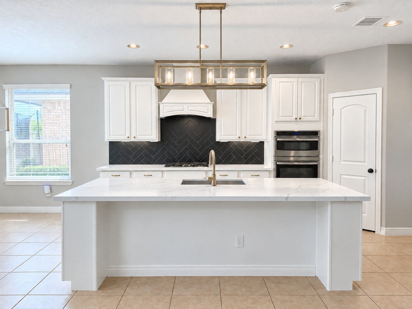 The beautifully remodeled kitchen combines timeless elegance with everyday functionality, featuring crisp white cabinetry, stylish backsplash, beautiful countertops, stainless steel appliances, and an inviting design that opens to the living area.