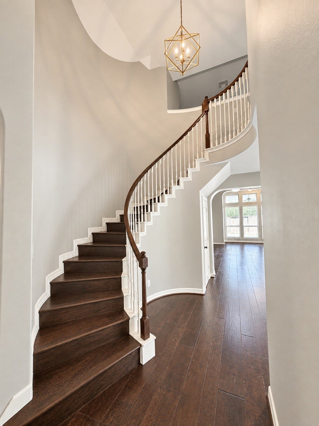 A stunning curved staircase takes center stage, creating a beautiful focal point that defines the home's grand entrance.