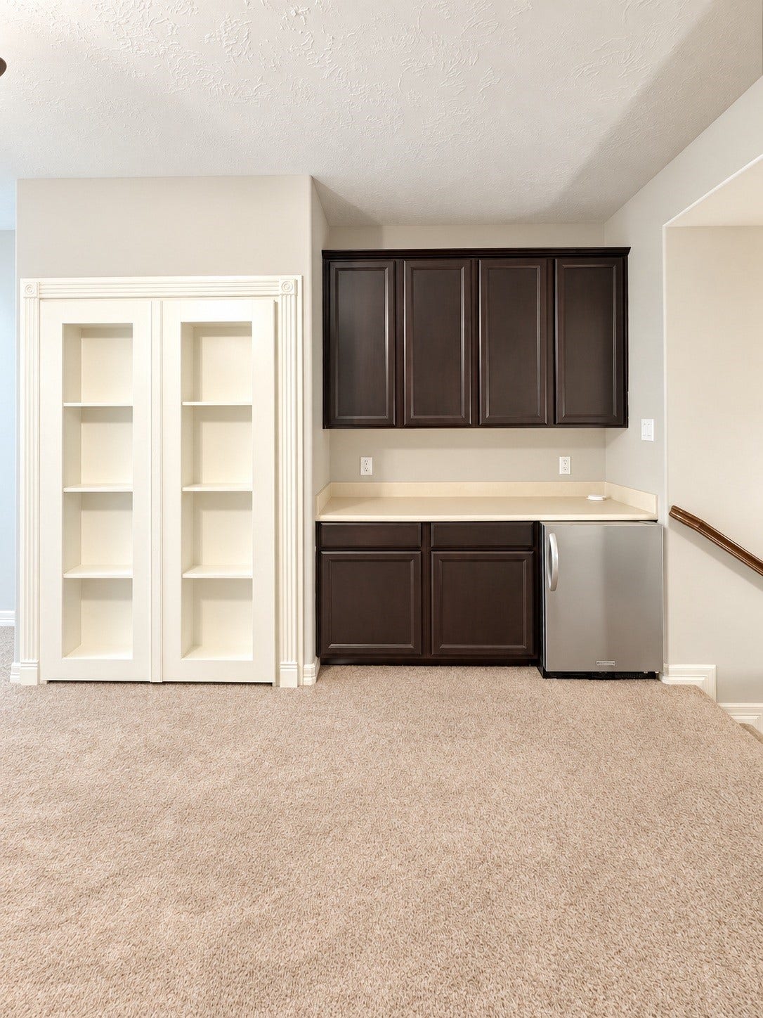 A stylish upstairs bar and custom bookcase add a unique touch to the entertainment space, with a hidden doorway leading to the private media room.