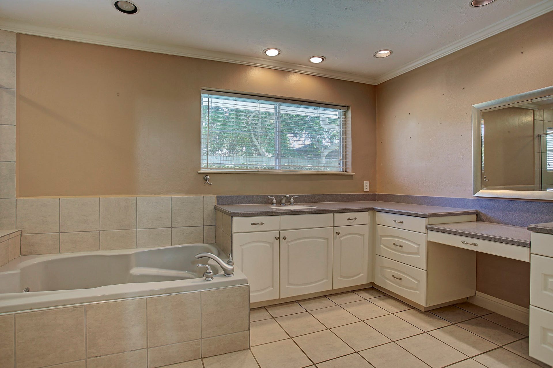 A long vanity, dedicated seated area, and soaking tub give the primary bath room for your whole routine.