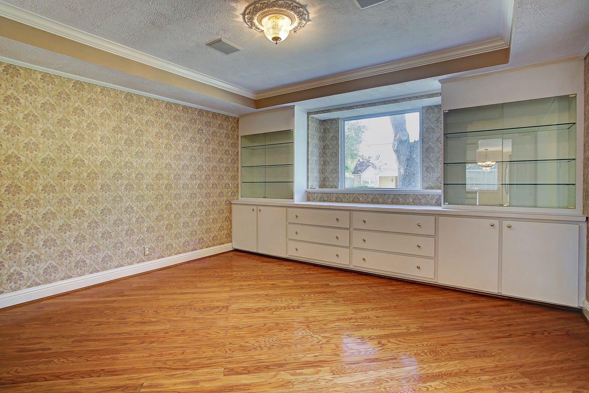 Your serving pieces finally have a home. Built-in drawers, cabinets, and display shelves make this dining room as useful as it is charming.