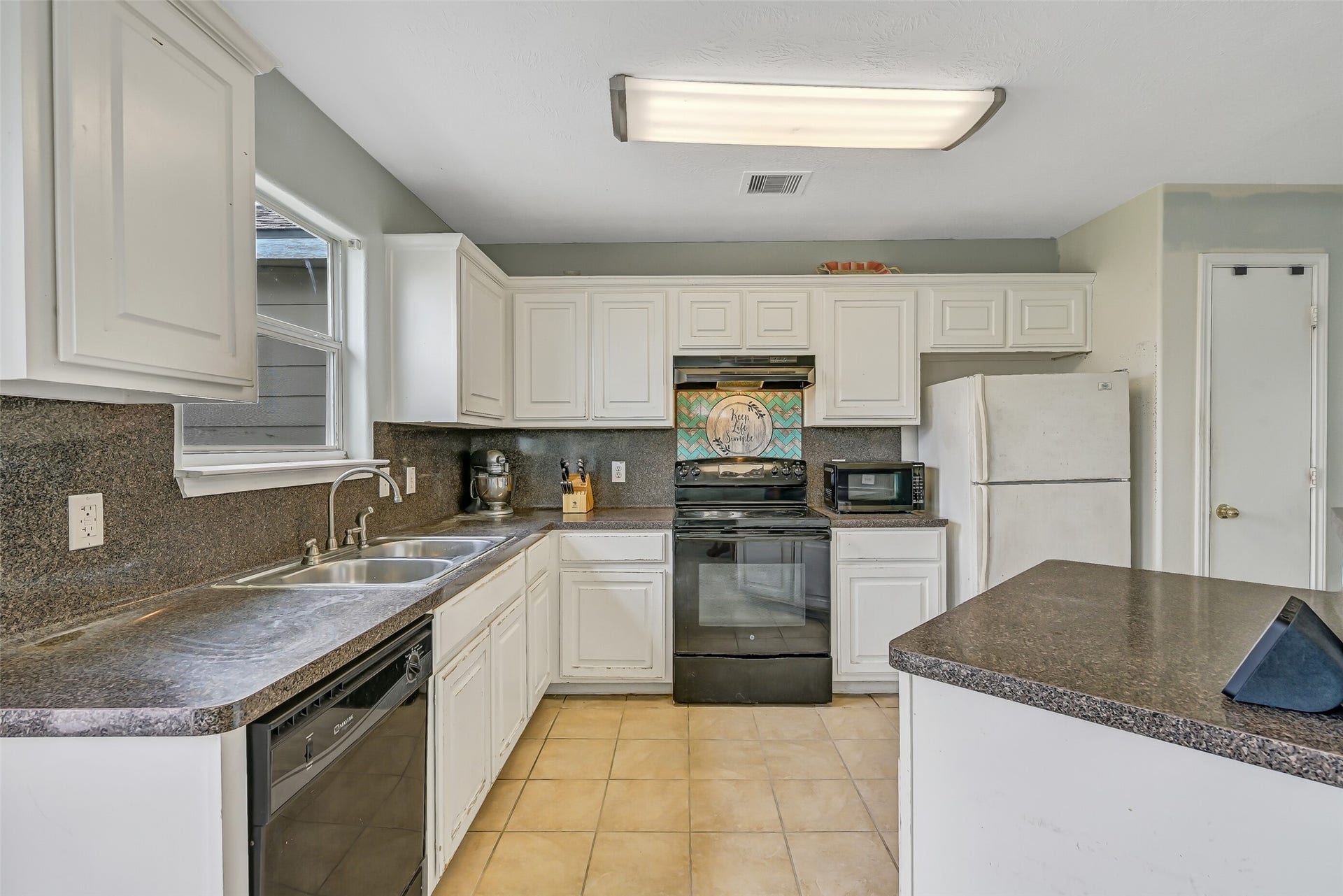 9022 Amberjack Drive, Texas City, TX 77591 Another view of the kitchen highlights the wraparound workspace, breakfast bar, electric range, dishwasher, and ample upper and lower cabinetry.